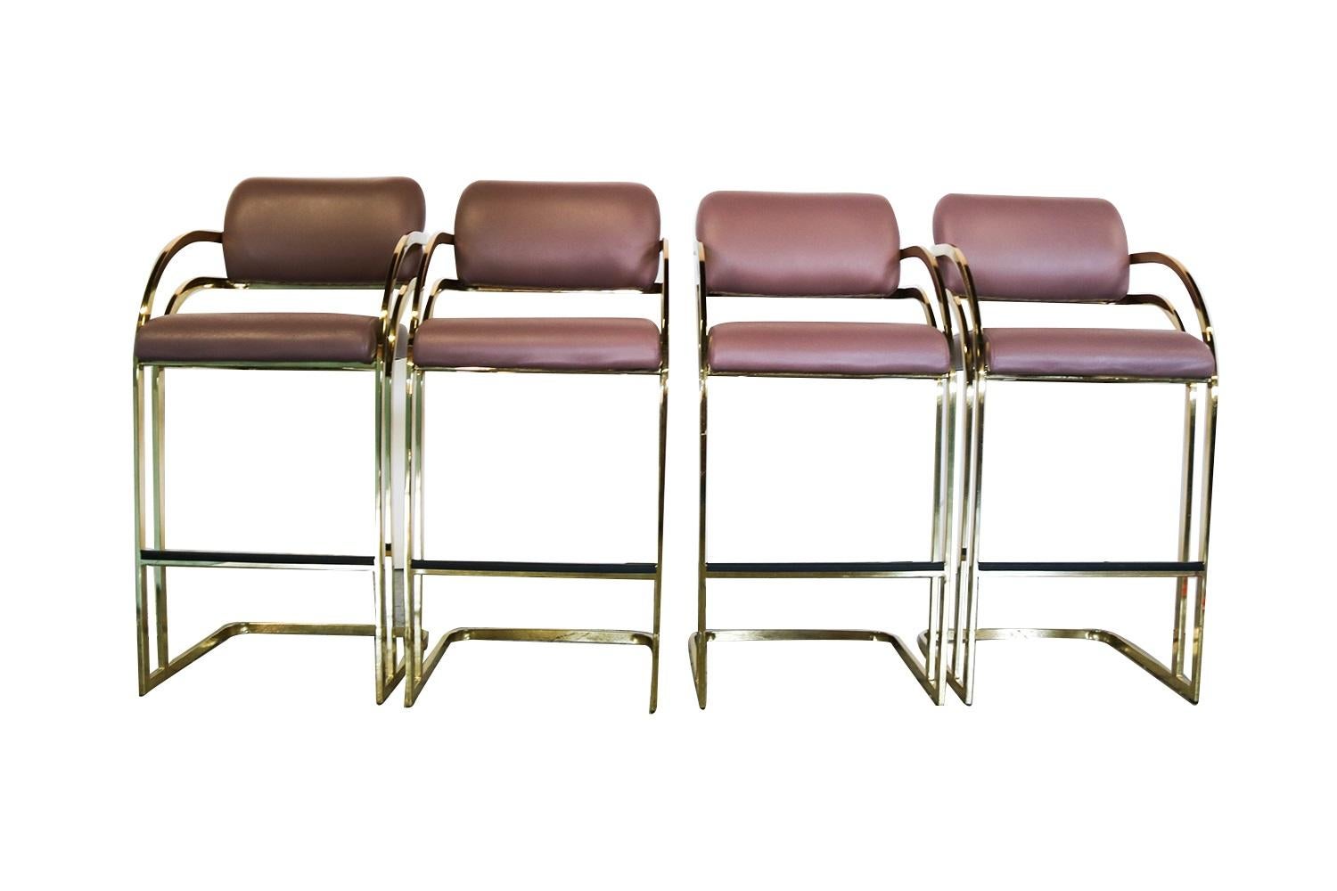 Stunning attractive set of four, brass Cantilever, tall, bar stools by Arthur Umanoff for Contemporary Shells. Features a beautiful, midcentury form, sophisticated and elegant with soft padded back over sculptural cantilevered “curved shape” double