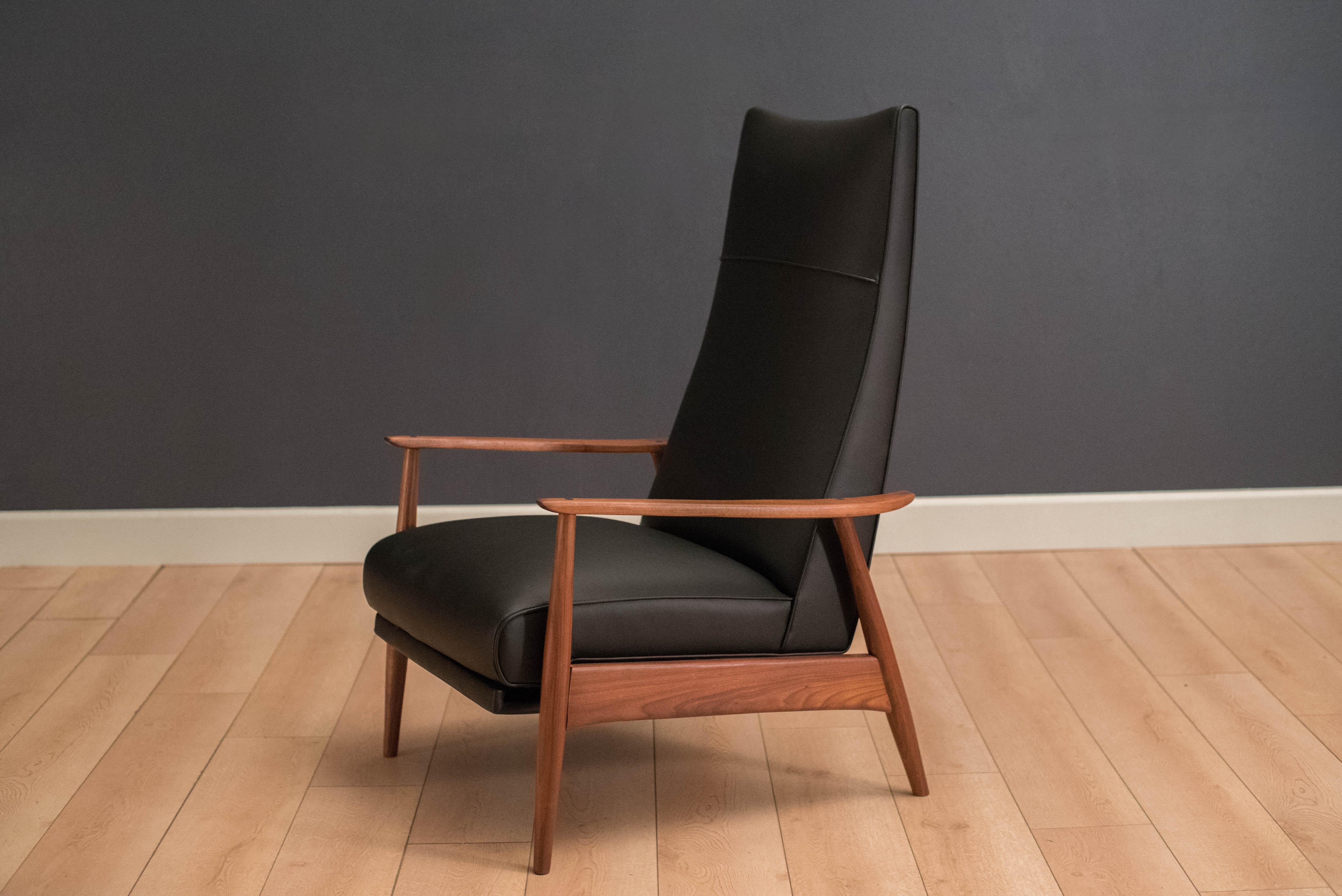 Mid-Century Modern high back reclining lounge chair designed by Milo Baughman for Thayer Coggin. This piece is made of solid walnut and is newly reupholstered in black vinyl. Lean back for two alternative reclining positions. 

57