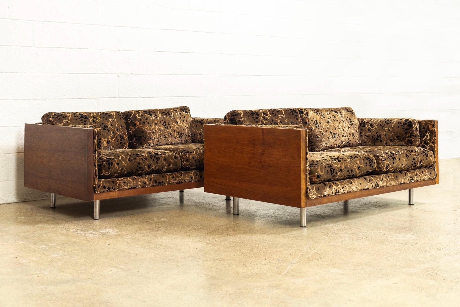 This pair of vintage Mid-Century Modern two-seat case loveseat sofas in the style of Milo Baughman and circa 1970 have incredible style. With a clean elegant profile, the loveseat couches feature two-seat cushions, two backrest cushions and two