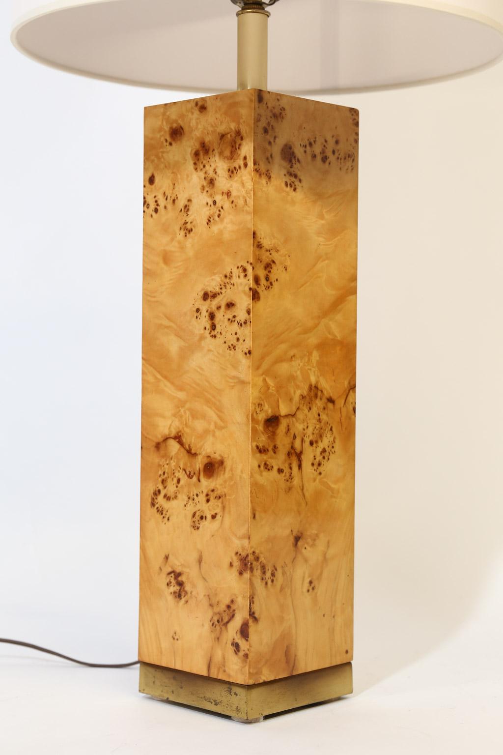 This beautiful Mid-Century Modern table lamp is made of burl wood and brass. The lamp boasts simple and clean lines consistent with the style of Milo Baughman. The lamp is accented with a brass base on the burl wood column. The shade is