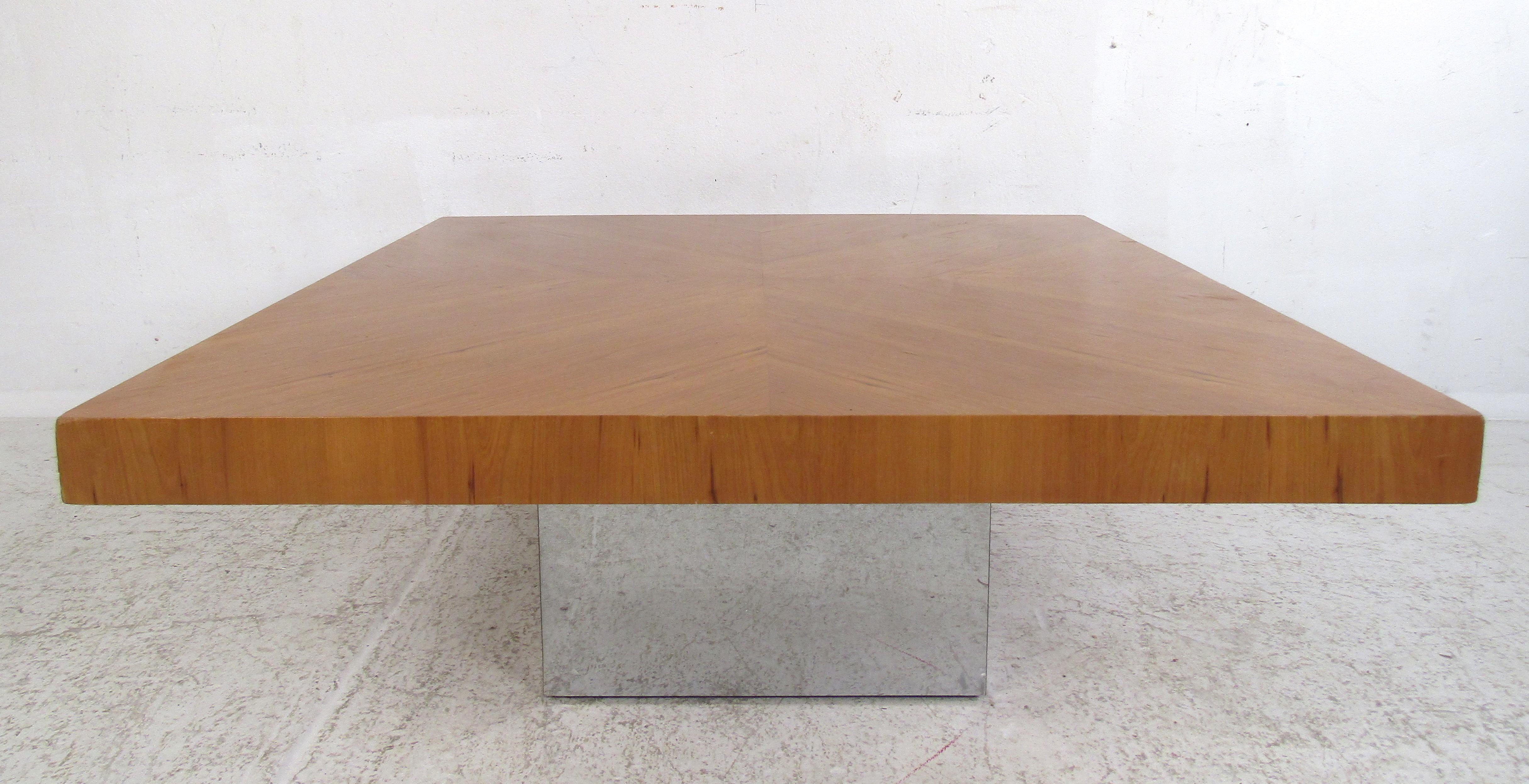 This stunning vintage modern coffee table boasts a matchstick woodgrain top with the grain running in different directions. A unique design that comfortably sits on a cubed pedestal chrome base. A square cocktail table that is sure to fit perfectly