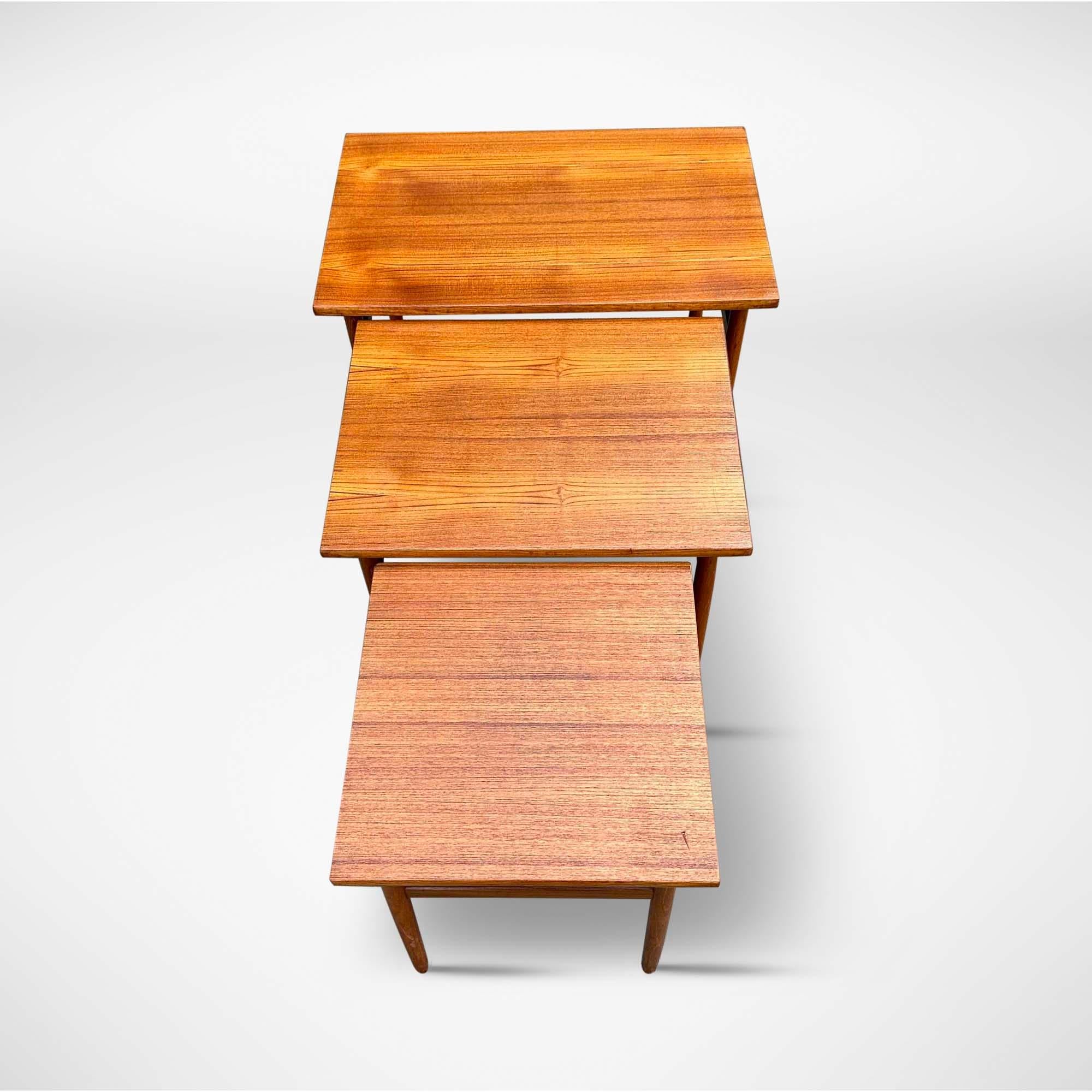 Set of 3 mid-century side tables with refined tapered legs. These nesting tables were designed by Dane Kai Kristiansen, circa 1960.  The coffee tables slide into each other, making them easy to put away. 

Denmark, 1960s

Designer/manufacturer: Kai