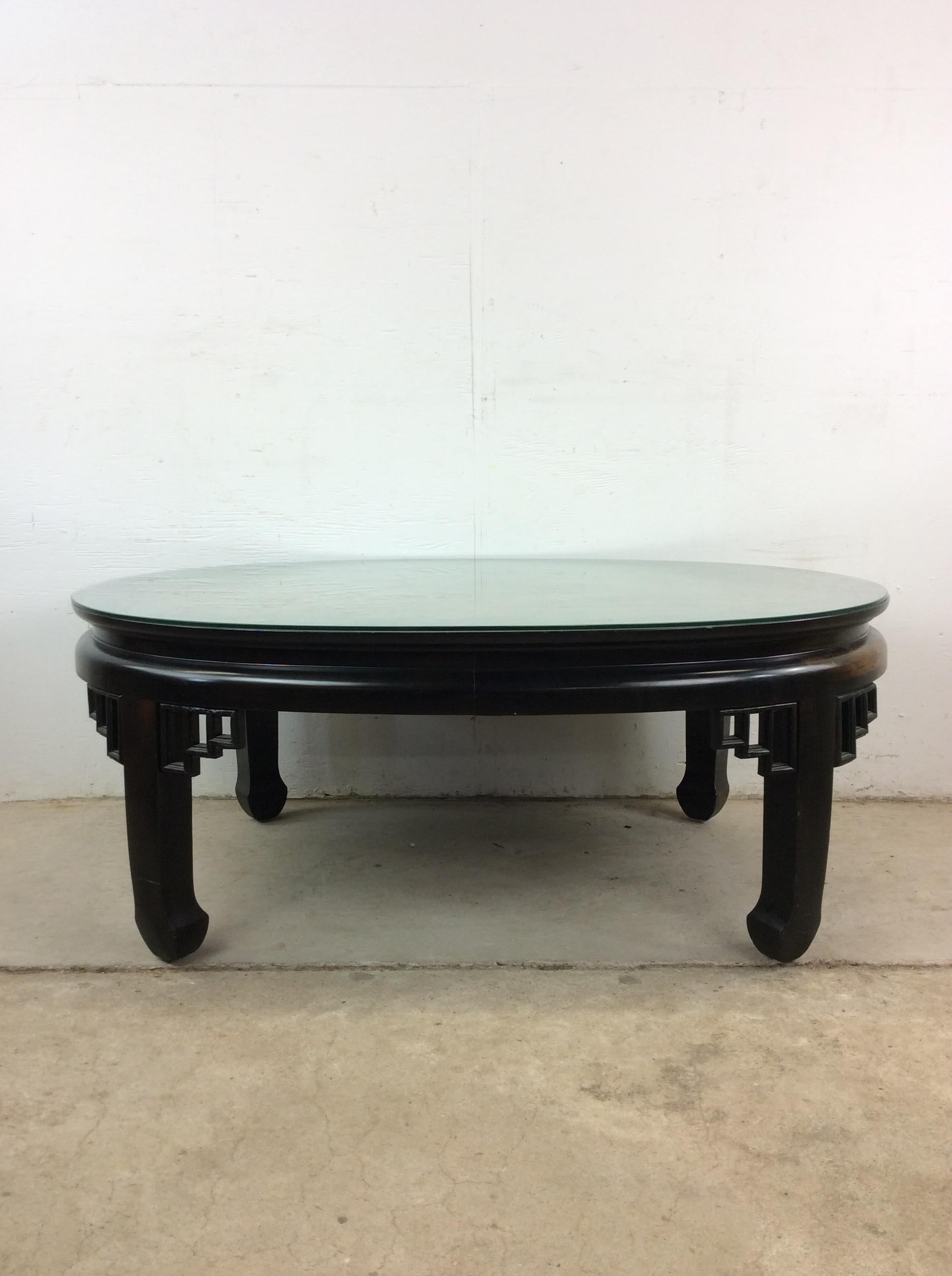 Esta mesa de centro de estilo Ming de mediados de siglo está fabricada en madera noble, tiene un acabado original en laca negra, un bonito tablero de madera de fresno, detalles de estilo Ming en las patas y la base, y un tablero de cristal