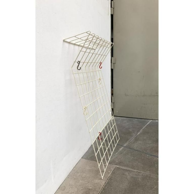 Gran armario de celosía de mediados de siglo en blanco.

Armario sencillo de rejilla metálica revestida. La parte superior tiene forma de estantería. Los ganchos originales de color se pueden mover como se desee.

Sin material de montaje para la