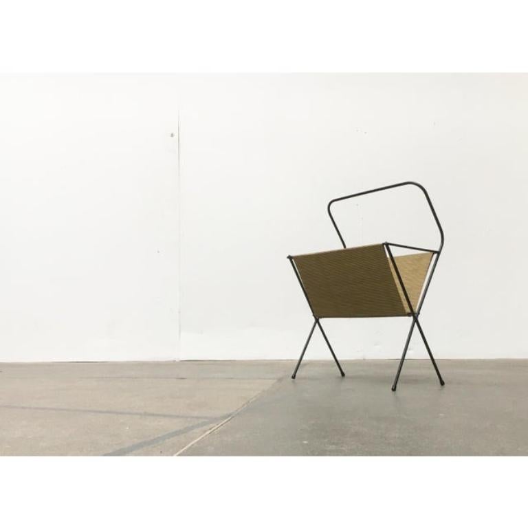 Minimalistischer Zeitungsständer aus der Mitte des letzten Jahrhunderts. Der Rahmen ist aus schwarzen Rundstäben gefertigt. Nach oben hin bildet er eine Klammer als Griff.

Zusätzliche Informationen:
MATERIALIEN: Metall
Stil: Moderne Mitte des