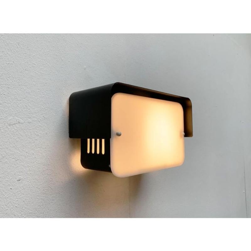 Lampada da parete minimalista di metà secolo.

Semplice lampada da parete in bianco e nero. Il corpo del Luminaire è costituito da una struttura rettangolare in metallo con tetto a vista. La parte anteriore è costituita da una lastra di plastica