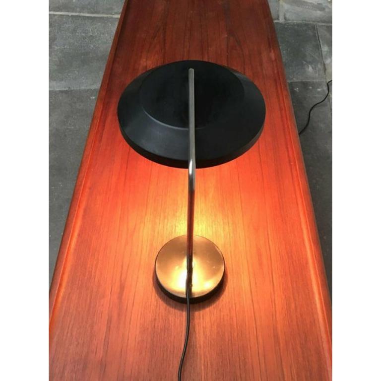 Very rare Mid-Century table lamp with swiveling umbrella.

This table lamp convinces with its straight design. Foot and umbrella are designed in black and connected to a chrome -plated arm made of round steel. The arm runs over the umbrella and
