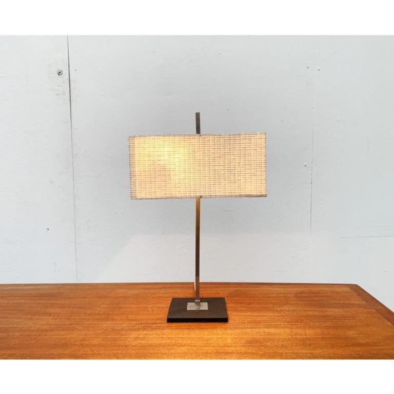 Rara lámpara de mesa de mediados de siglo.

Un diseño minimalista en un lenguaje de diseño factual. La pantalla presenta una forma básica cuadrada y está recubierta de un material plástico brillante y estructurado. La parte superior está protegida