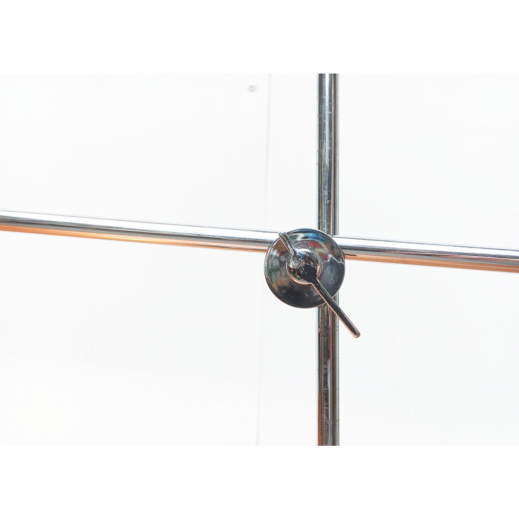 Minimalist Mid Century table lamp.

A very minimalist design in shape and color. The lamp is completely in chrome and black. The respective poles - shade and base - are finished in black. The connecting elements- stem and arm - in chrome. Shaft and