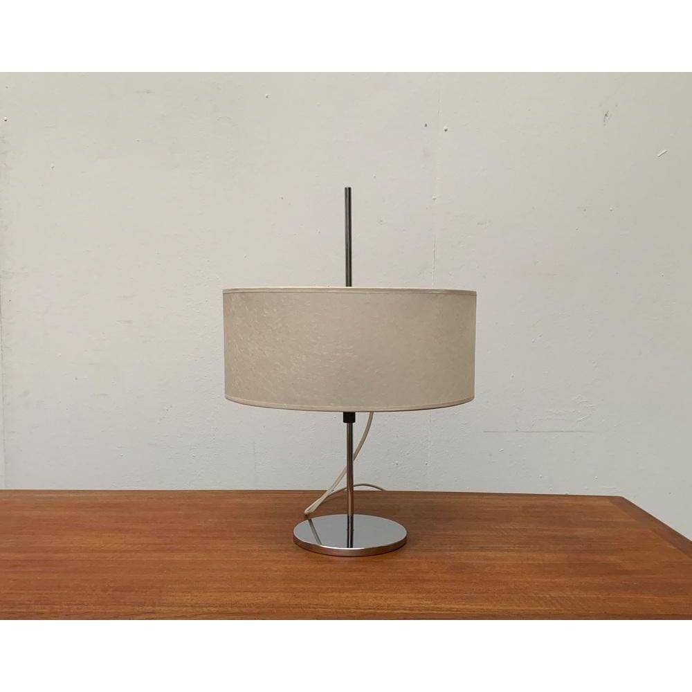 Minimalist Mid Century table lamp.

Particularly insisting falls the fine execution of the individual elements of the light. The shaft is particularly thin and made of solid material. The simple plate foot is shiny polished. The drum-shaped screen