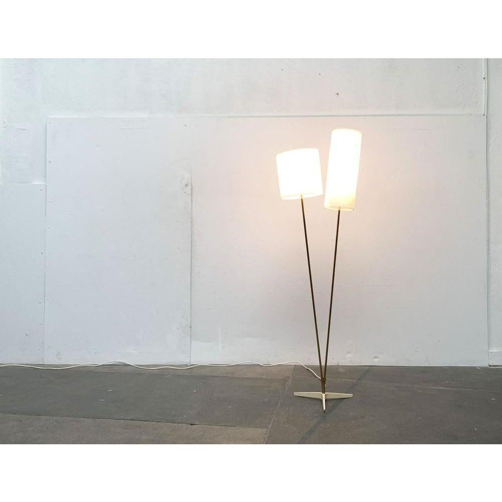 Eleganza della lampada da terra di metà secolo con due paralumi.

Un design riservato e dettagliato. La materialità e la colorazione sono sorprendenti. Il piede cattura l'attenzione. Questa mostra una forma a stella ed è ricoperta da una lacca