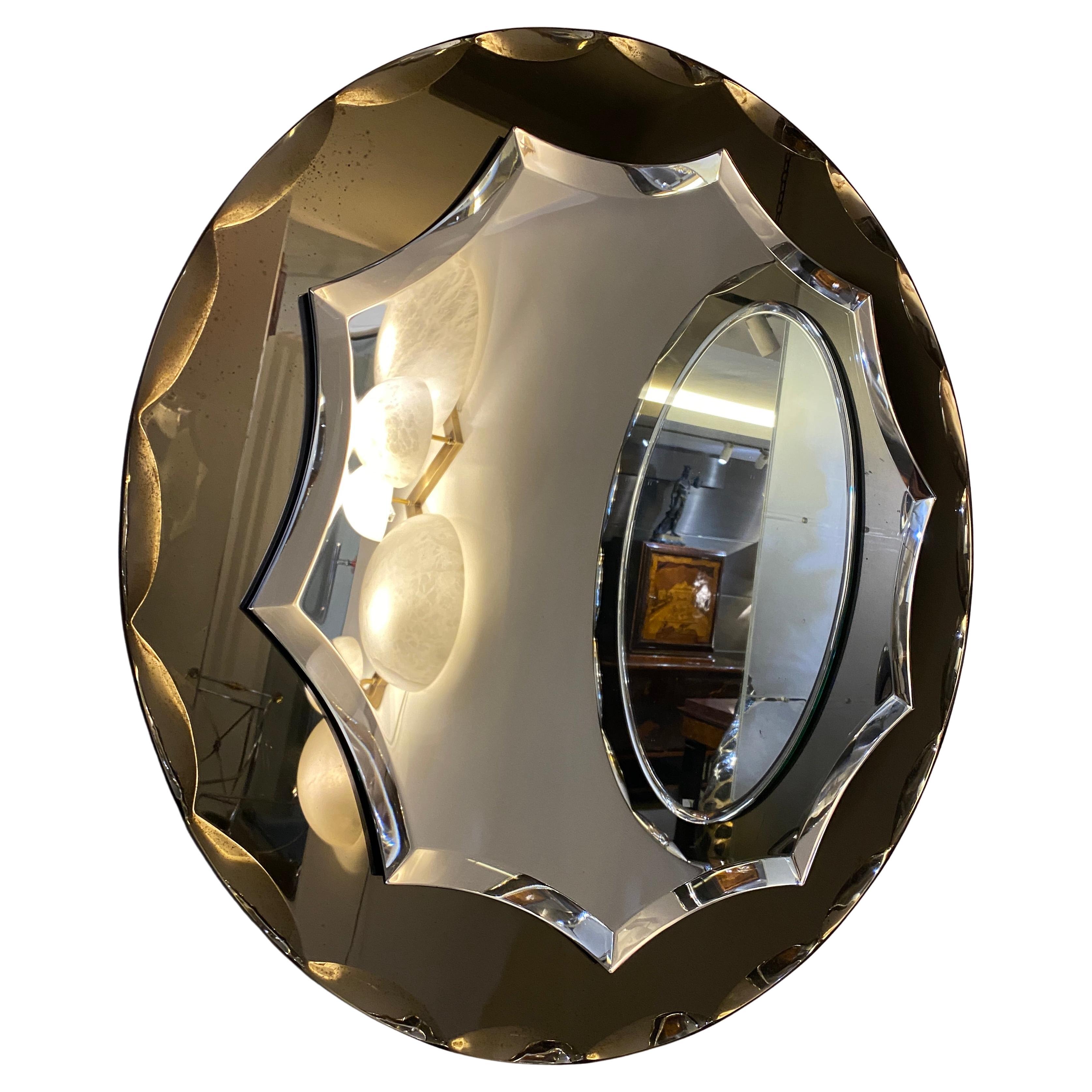 Magnifique miroir attribué à Max Ingrand pour Fontana Arte. Le miroir est en verre facetté de couleur fumée encadré.
Il s'agit d'un reflet de quelque chose d'autre, qui n'a rien à voir avec le miroir.
 