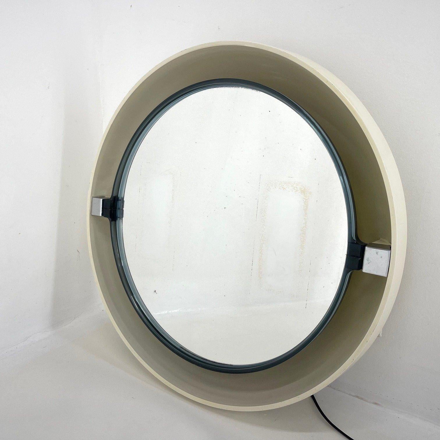 Beautiful vintage back-lit mirror. The back is made of plastic, the mirror itself is adjustable. There is a cord on the side for switching the light on and off. There are some signs of use (see photo).