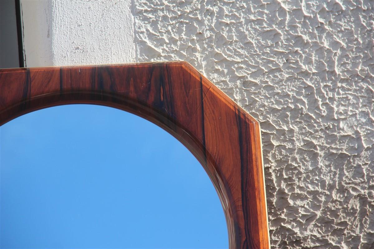 Specchio di metà secolo in palissandro ottagonale, design italiano, 1950.
Legno di palissandro ricoperto da una spessa resina plastica, in alcuni punti sembra un po' danneggiato come nella foto.