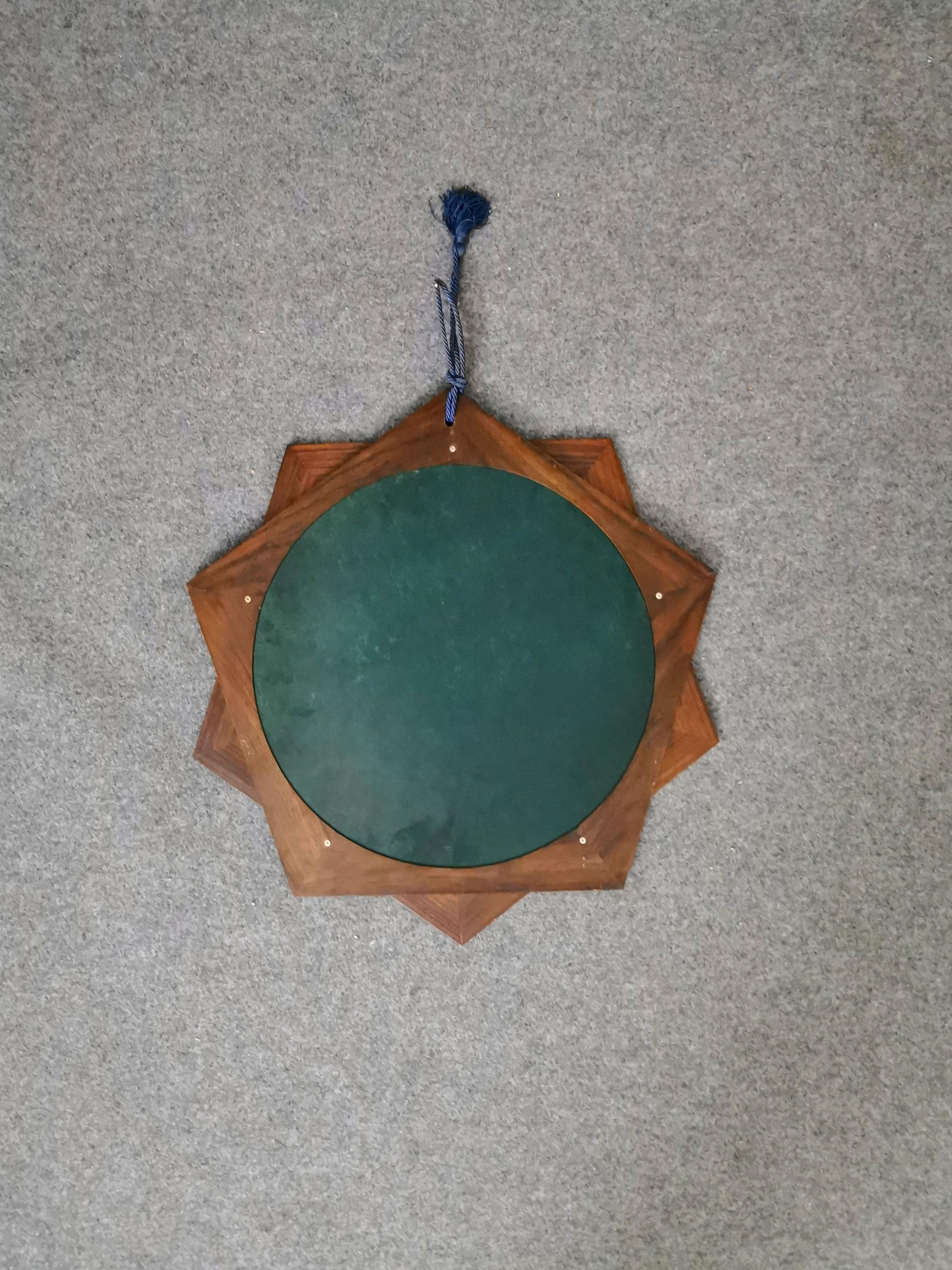 Small and particular wall mirror in rosewood in the shape of a 10-pointed star, with rope on the tip. Italian production of the 1970s.