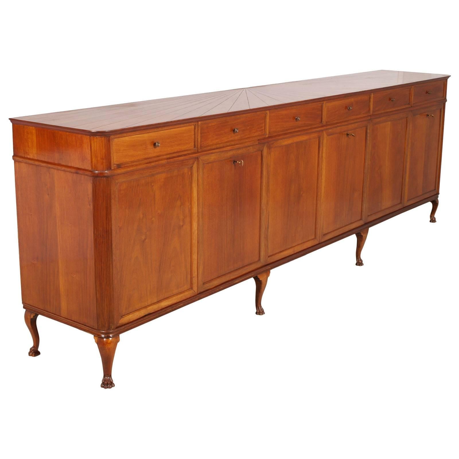 Important  sideboard with a wall mirror manufactured by Atelier di Varedo, circa 1940s. All in solid blond walnut with the top built in a radial pattern; hand carved legs in the shape lion; interiors in walnut veneer with red lacquered bottom.