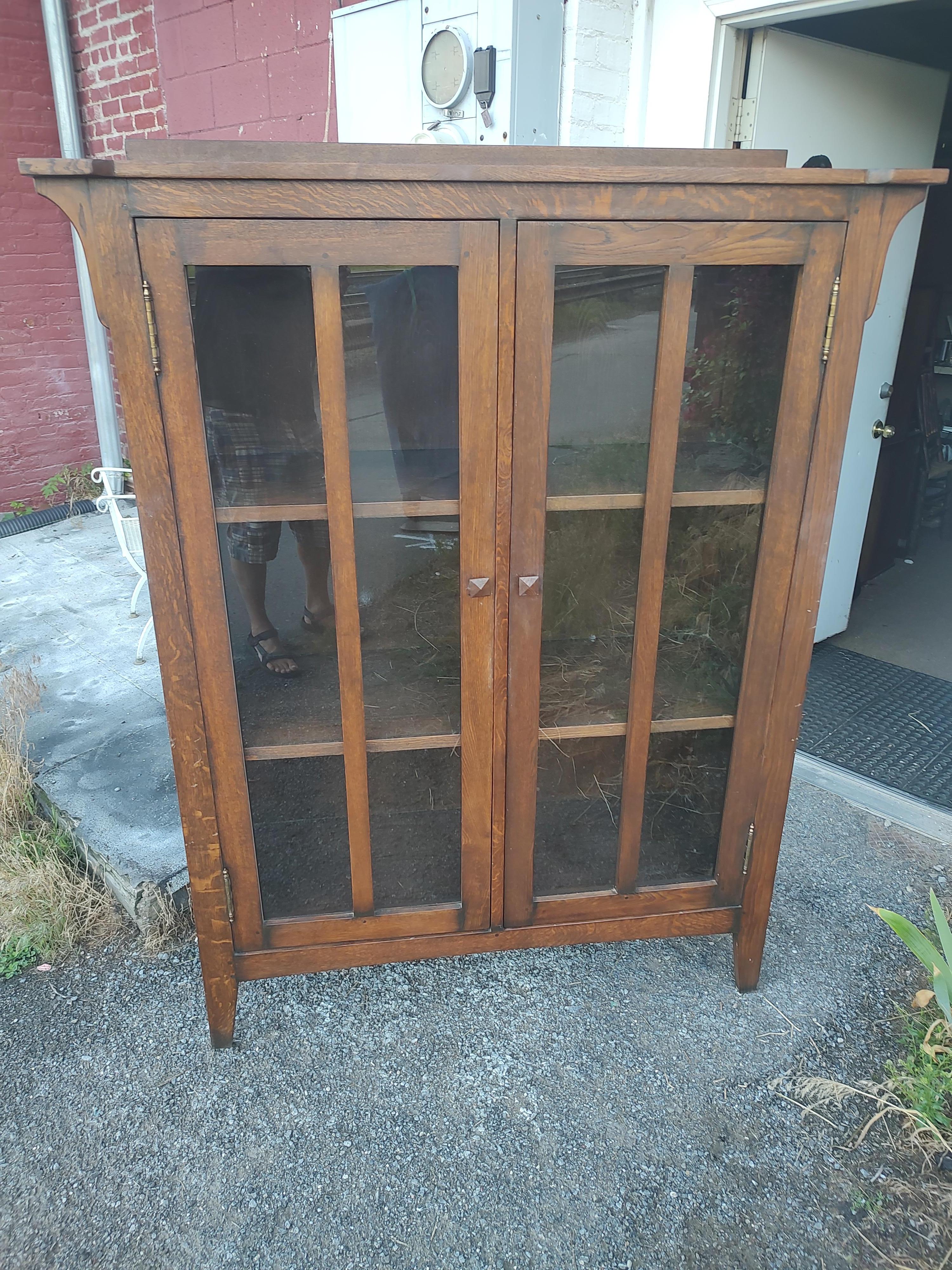 Great style and size in this Mission Arts and Crafts Bookcase / China Closet. Created from oak the cabinet design roots were in the early part of the 19th century. All the arts & crafts details a big part of this bookcase design. Looks to be all