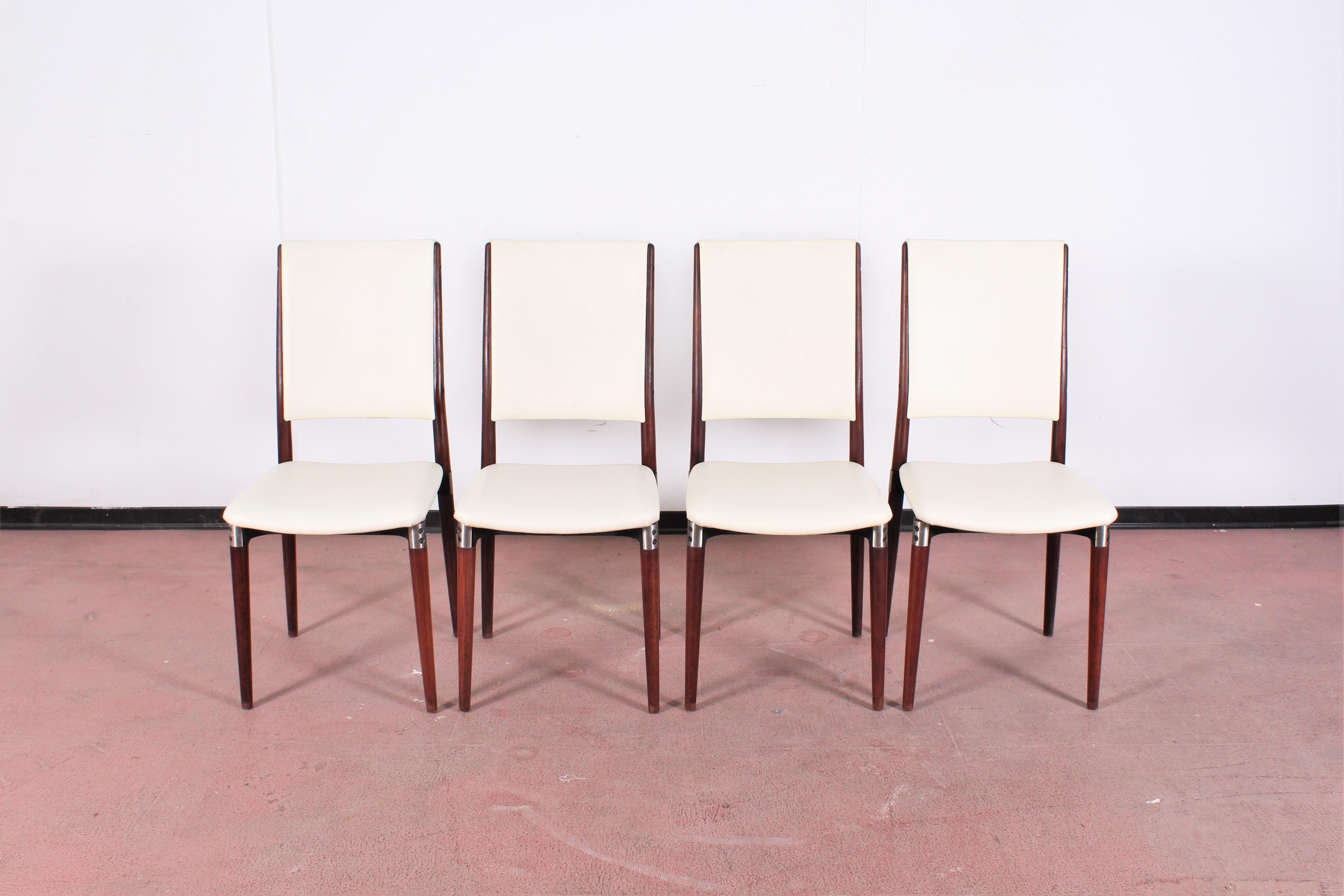 Four beautiful wooden chairs with cream-colored eco-leather upholstery and metal supports. Mod. 