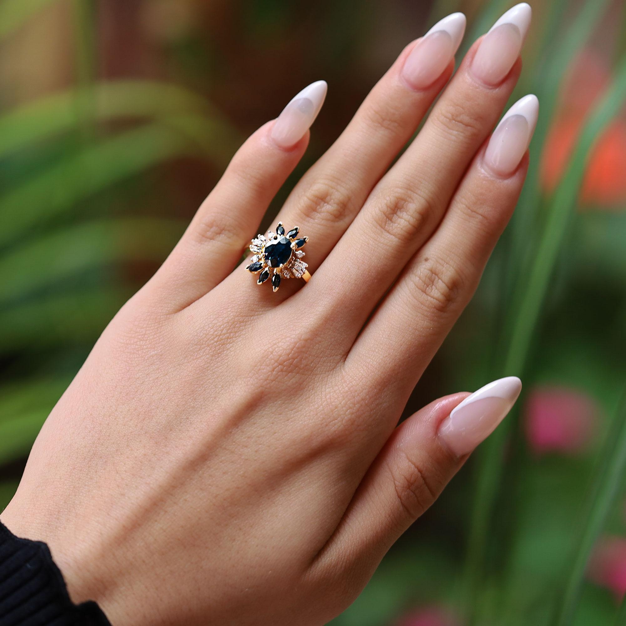 Capture Mid Century modern elegance with this space age inspired sapphire and diamond vintage cocktail ring. An asymmetrical orbit of twinkling round diamonds enhance the central 1.40 carat gemstone of a deeply saturated greenish blue, reminiscent