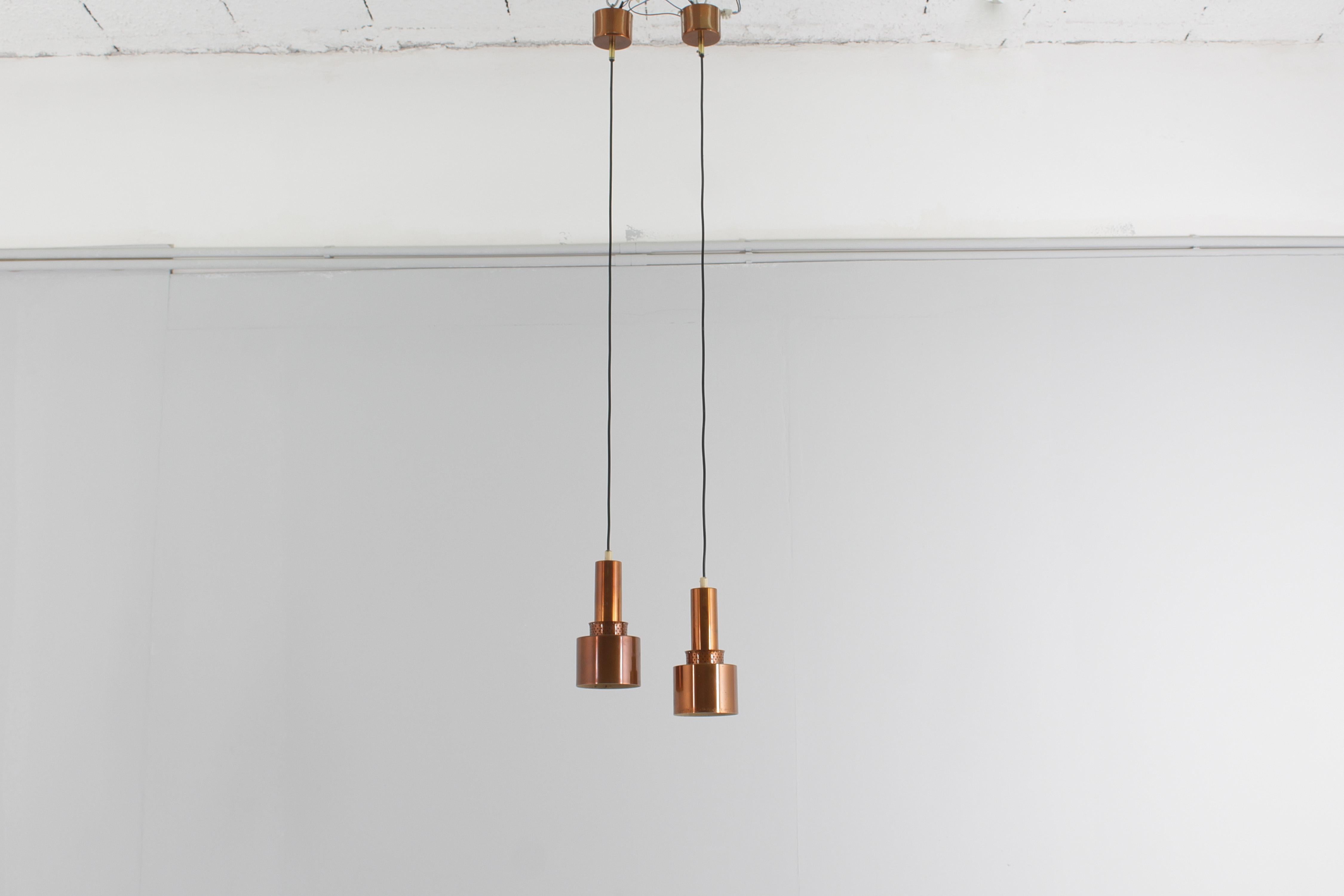 Wonderful set of 2 pendants model T292 in copper by Hans-Agne Jakobsson for Hans-Agne Jakobsson AB Markaryd. This model was designed in 1958 and is quite rare. The light spreads beautifully from the perforated copper above the bulb. 