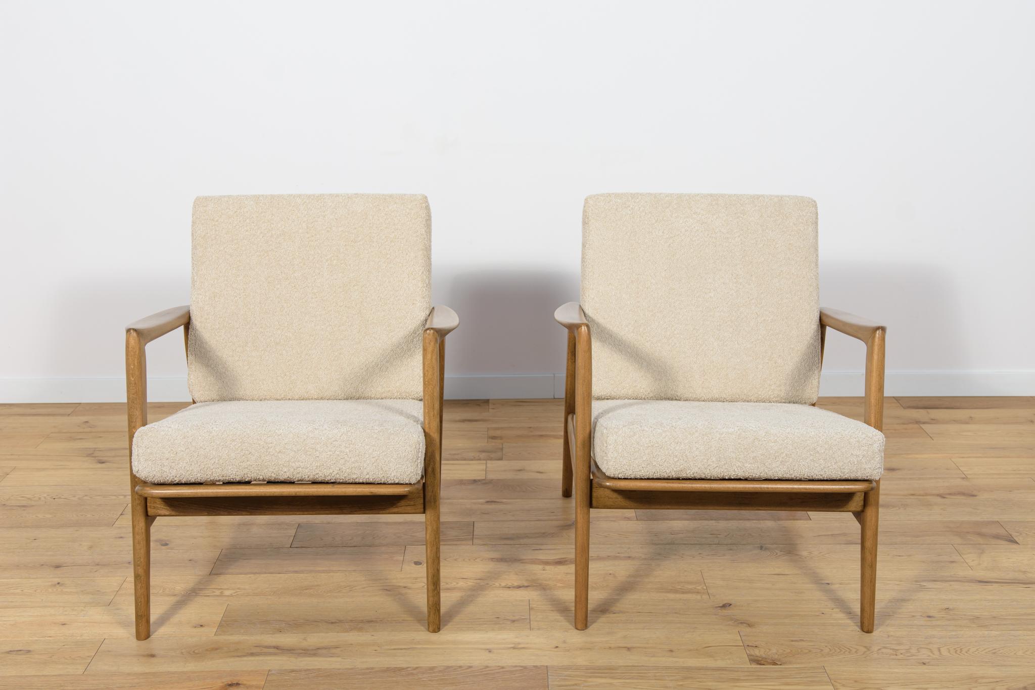 
This pair of armchairs was produced by the Polish company Swarzędzka Furniture Factory in 60s. Comfortable armchairs with a unique form. Cushions replaced with new ones, upholstered in high-quality boucle typ fabric in a cream color. The beech
