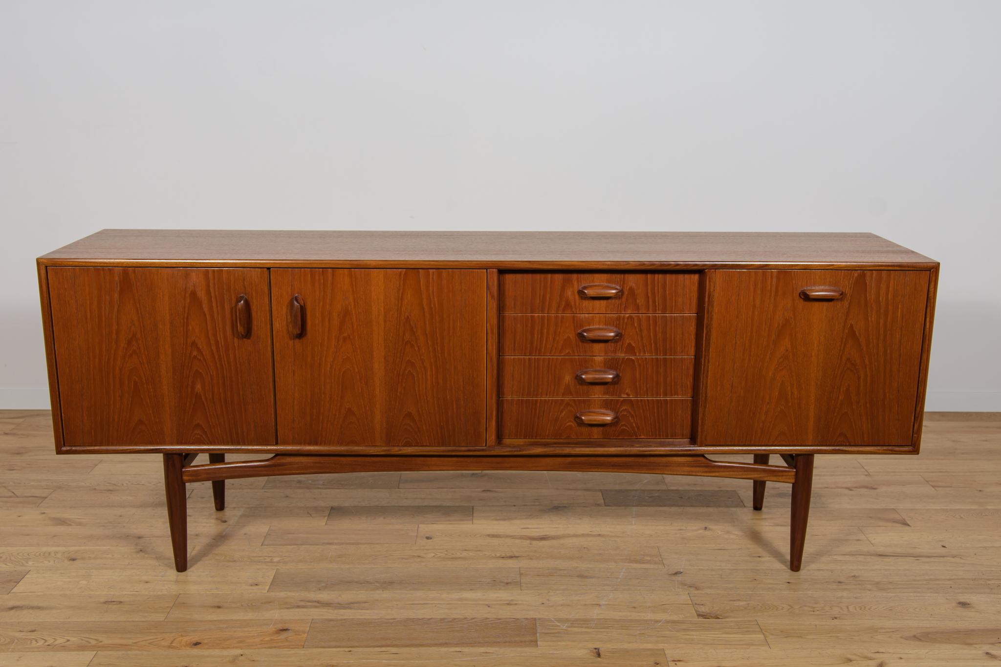 Sideboard Model 4058 is part of the fresco series and in teak designed by Victor Wilkins for G-Plan in the 60s. The sideboard with a light, sublime form with profiled handles. It has four drawers and three doors. Completely restored, teak elements