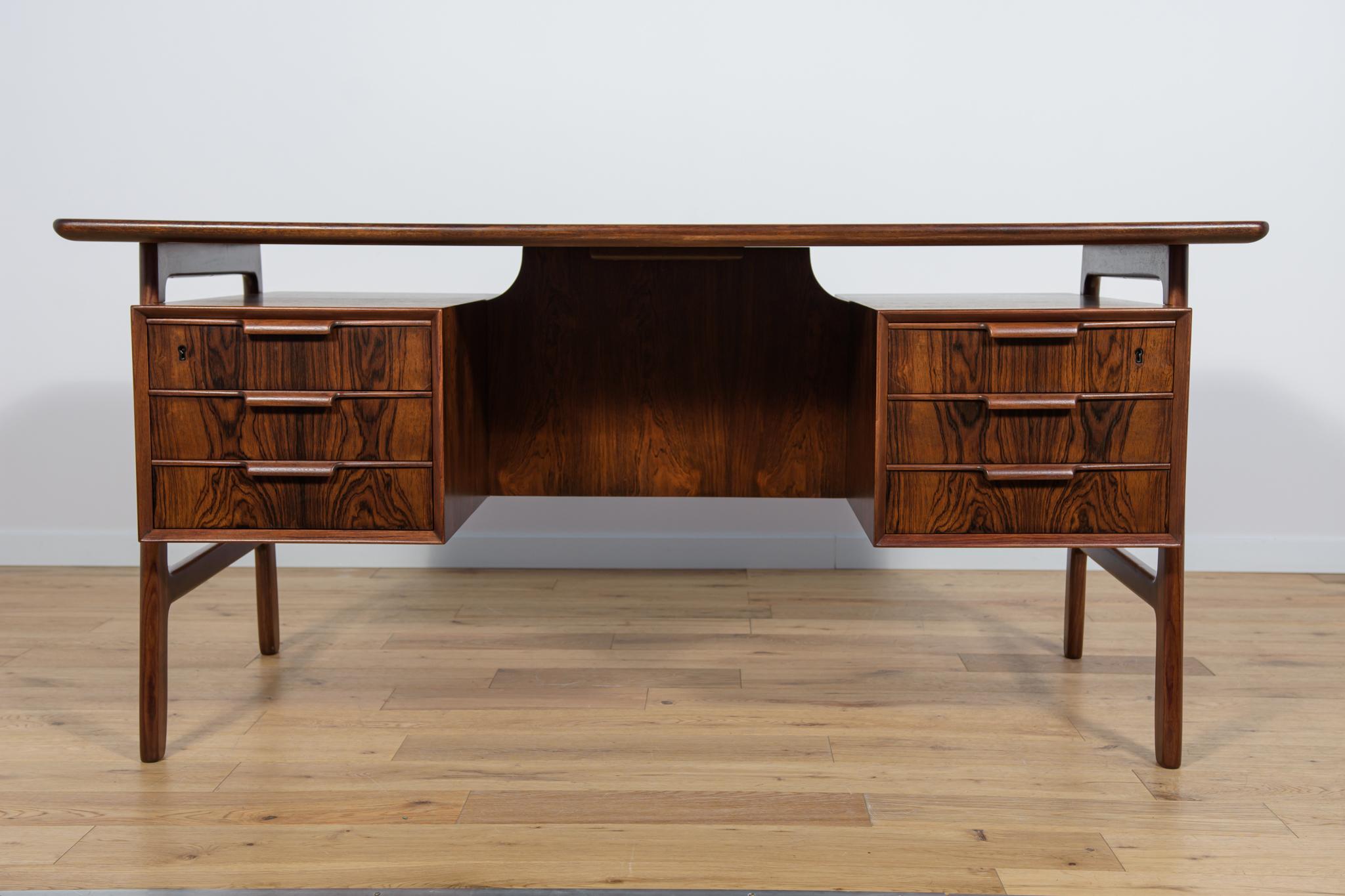 Bureau du milieu du siècle, modèle 75, produit par la fabrique de meubles danoise Omann Jun. Un bureau au design et à la fabrication de haute facture, caractéristique du design danois des années 1960. A l'avant, deux modules de 3 tiroirs chacun, à