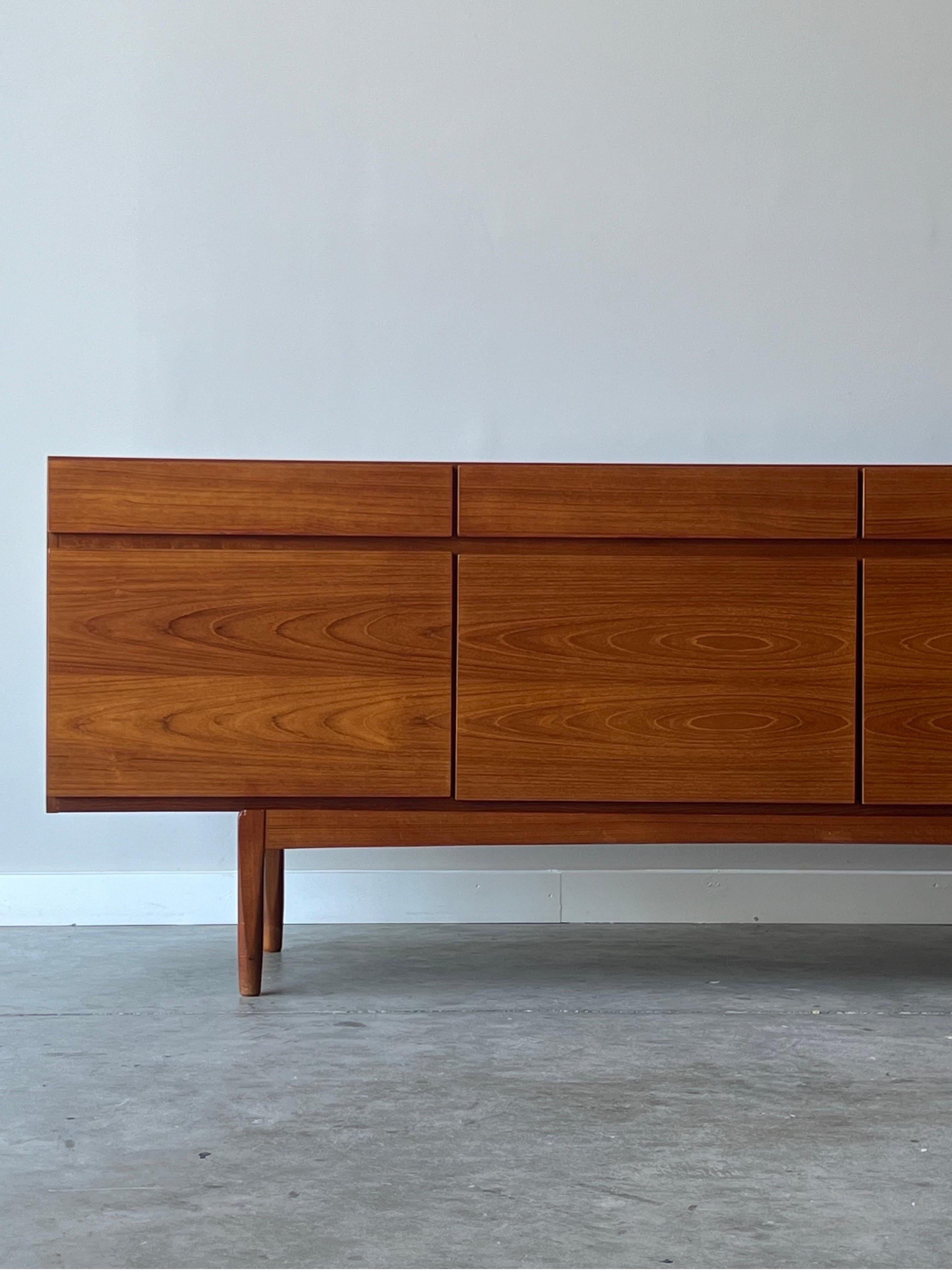 Large mid-century teak sideboard or credenza. This model FA-66 credenza was designed by Ib Kofod Larsen for Faarup Møbelfabrik, circa 1960s. Quintessentially Danish streamlined design with gorgeous book-matched teak. Extremely versatile piece as it