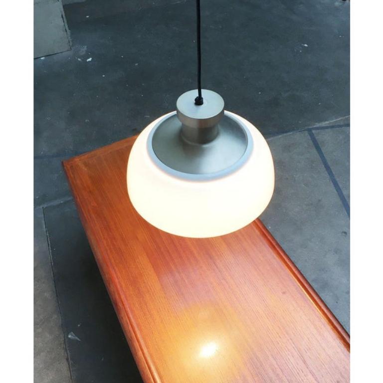 Rara lampada a sospensione di Kartell disegnata da Achille e Pier Giacomo Castiglioni nel 1959.

La lampada è composta da due parti, la struttura in metallo e il paralume in plastica. La particolarità è proprio questa combinazione di materiali. Il