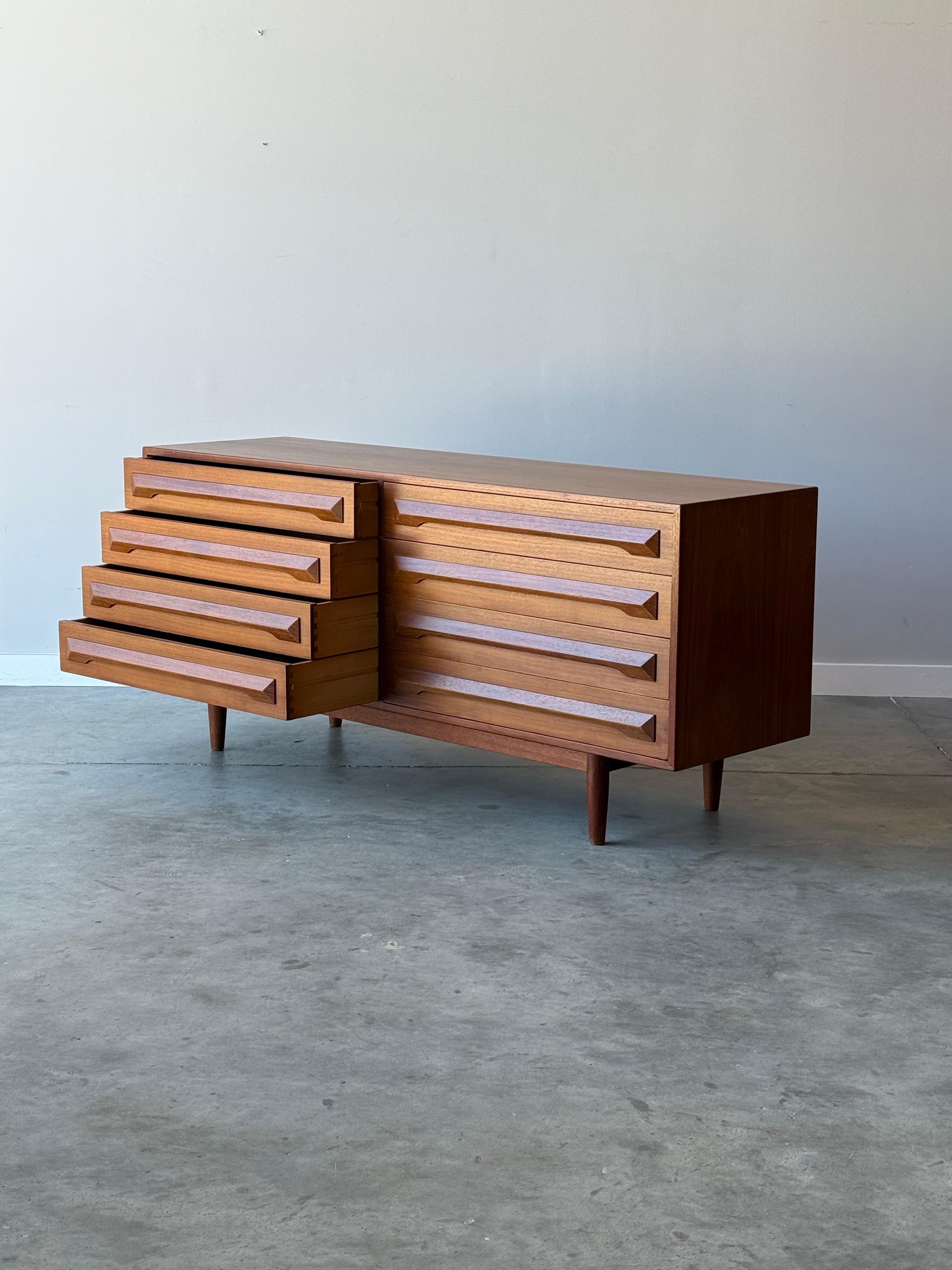Mid-century model no. 82 dresser designed by Kofod Larsen for Silkeborg Møbelfabrik, Denmark. Made from teak wood and featuring eight smooth-sliding drawers. Each drawer has carved teak wooden handles. Handles are rectangular in shape and frame the