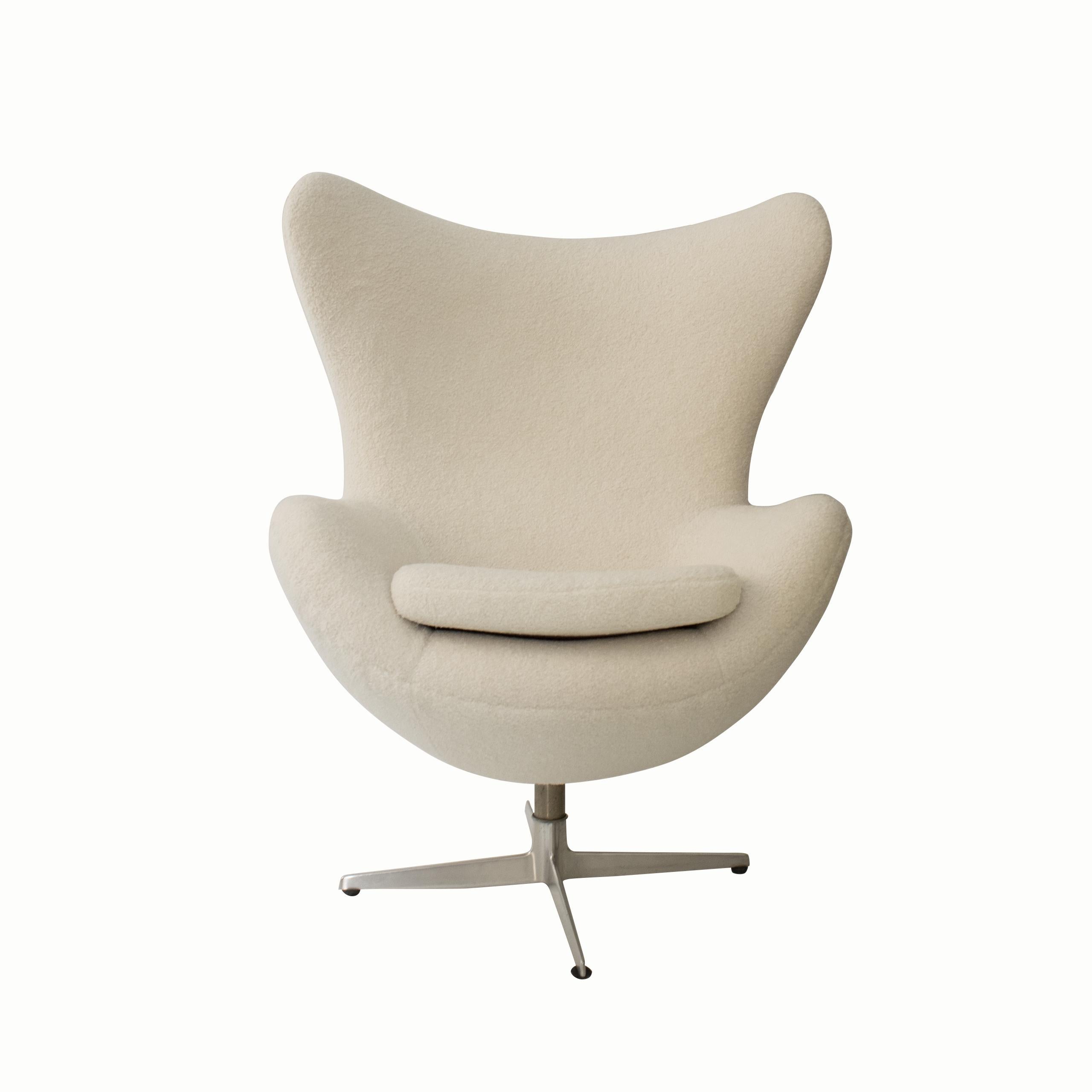 Egg Chair was designed by Arne Jacobsen in 1958 for the SAS Hotel in Denmark. and is made with a birch plywood frame covered with foam and fabric padding, a technique pioneered by Jacobsen. This item has been reupholstered in beige buclé.