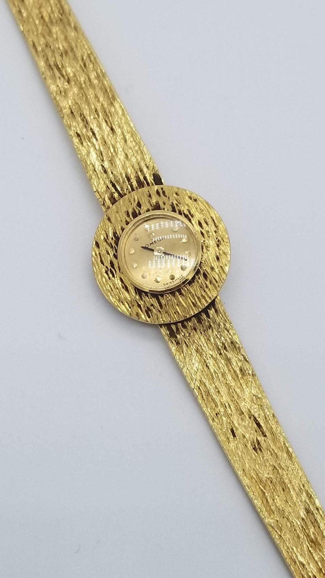 This Mid-Century Modern Omega 14-karat women's wristwatch features 17 jewel movement and a textured gold band. Stamped 