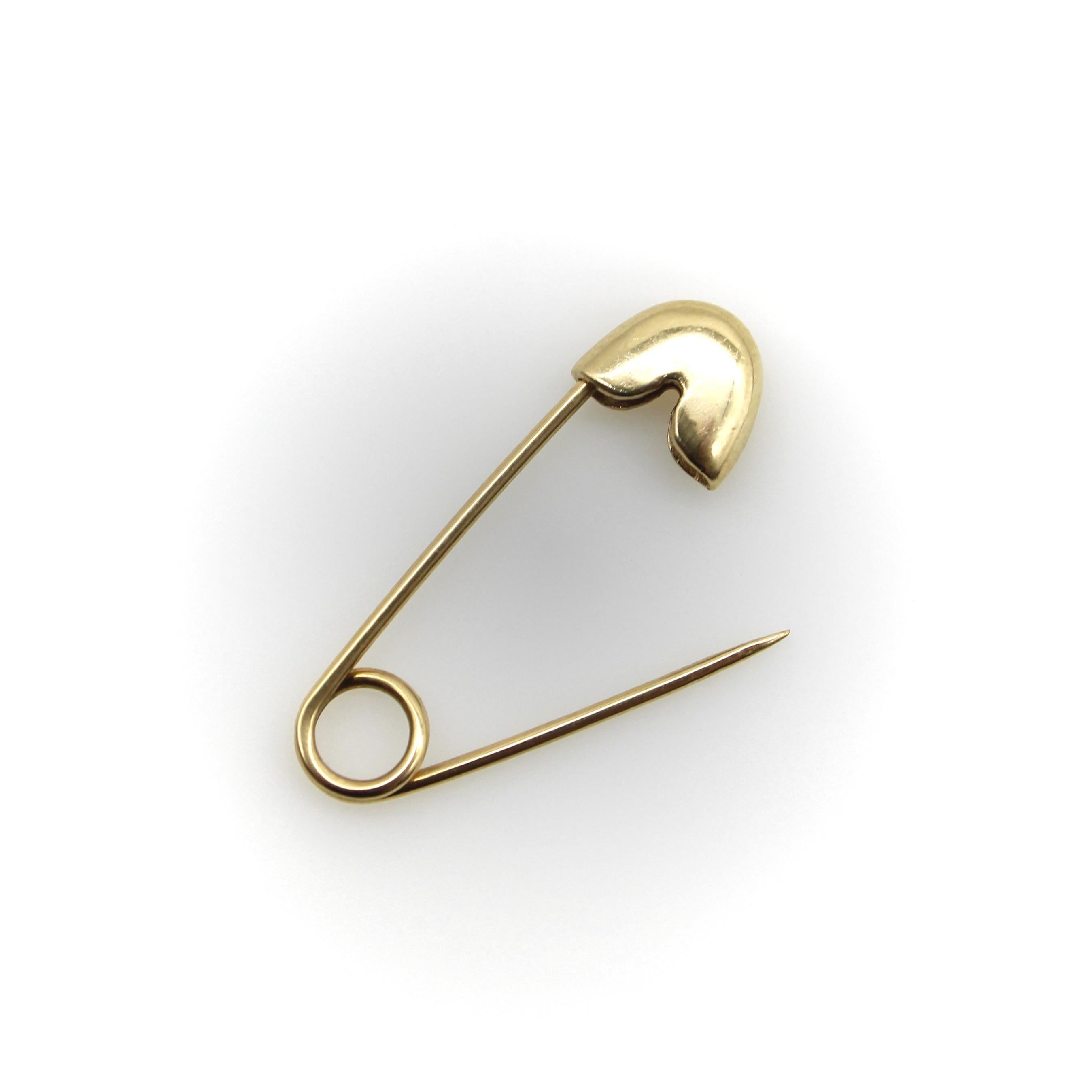 Diese stets funktionale und begehrenswerte Sicherheitsnadel aus 14-karätigem Gold ist ein unverzichtbares Stück in jeder Schmucksammlung. Sie hat eine angenehme Größe und kann sowohl als Brosche als auch als Kettenverlängerung verwendet werden, was