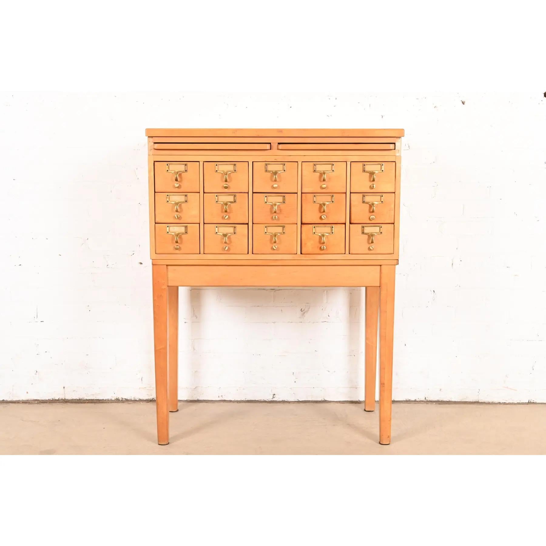 Eine seltene Mid-Century Modern 15-Schublade Bibliothek Zettelkatalog oder Aktenschrank mit zwei ausziehbaren Schreibtafeln

Nach dem Vorbild von Remington Rand

USA, ca. 1950er Jahre

Ahornholz, mit originalen Messingbeschlägen.

Maße: 33,5 