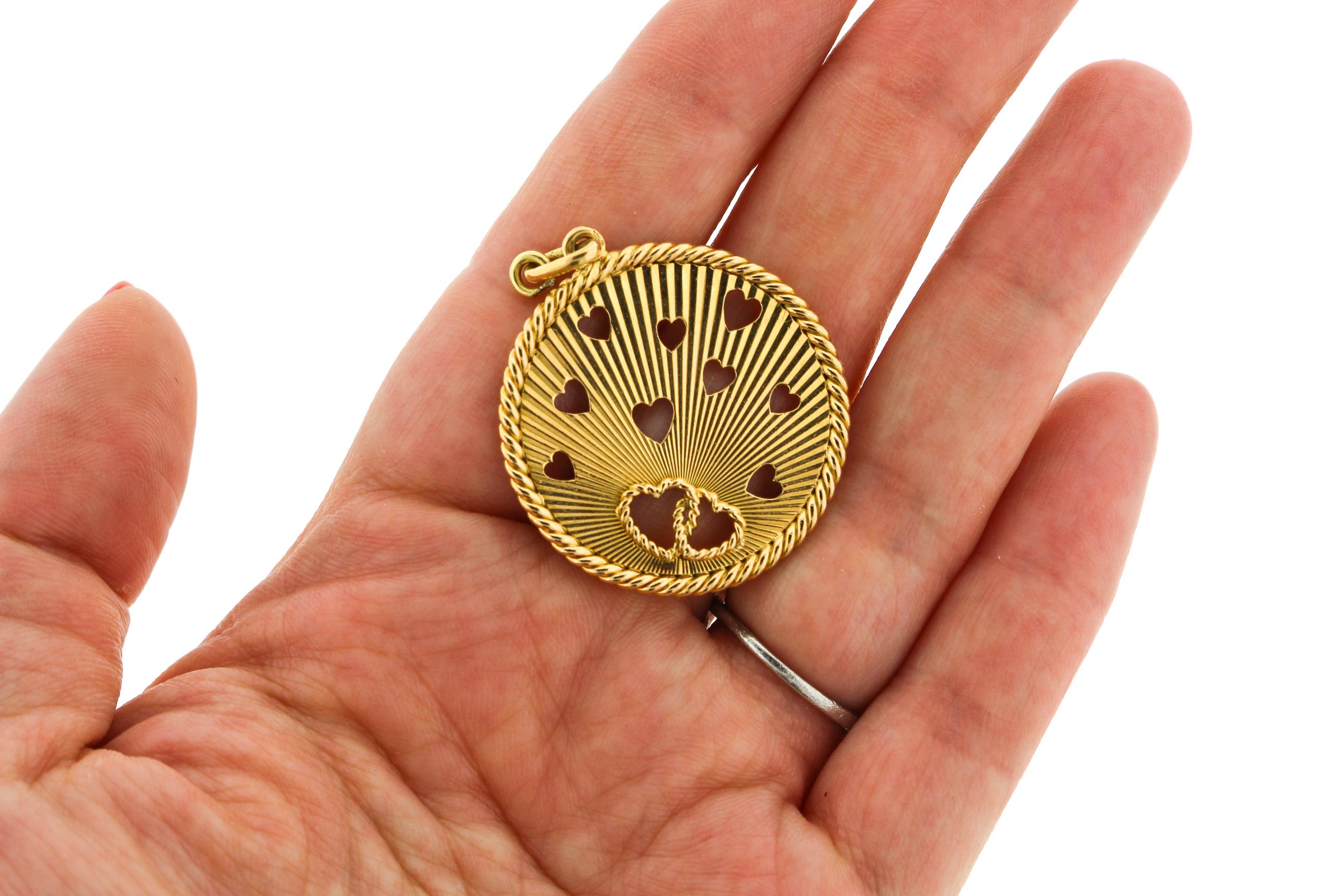 Mid-Century Modern 18k yellow gold heart charm pendant made in France around 1965. The charm which has fluted gold details with cut out hearts and a twisted gold rim is sheer whimsy. The ultimate love token. The charm has French hallmarks for 18k