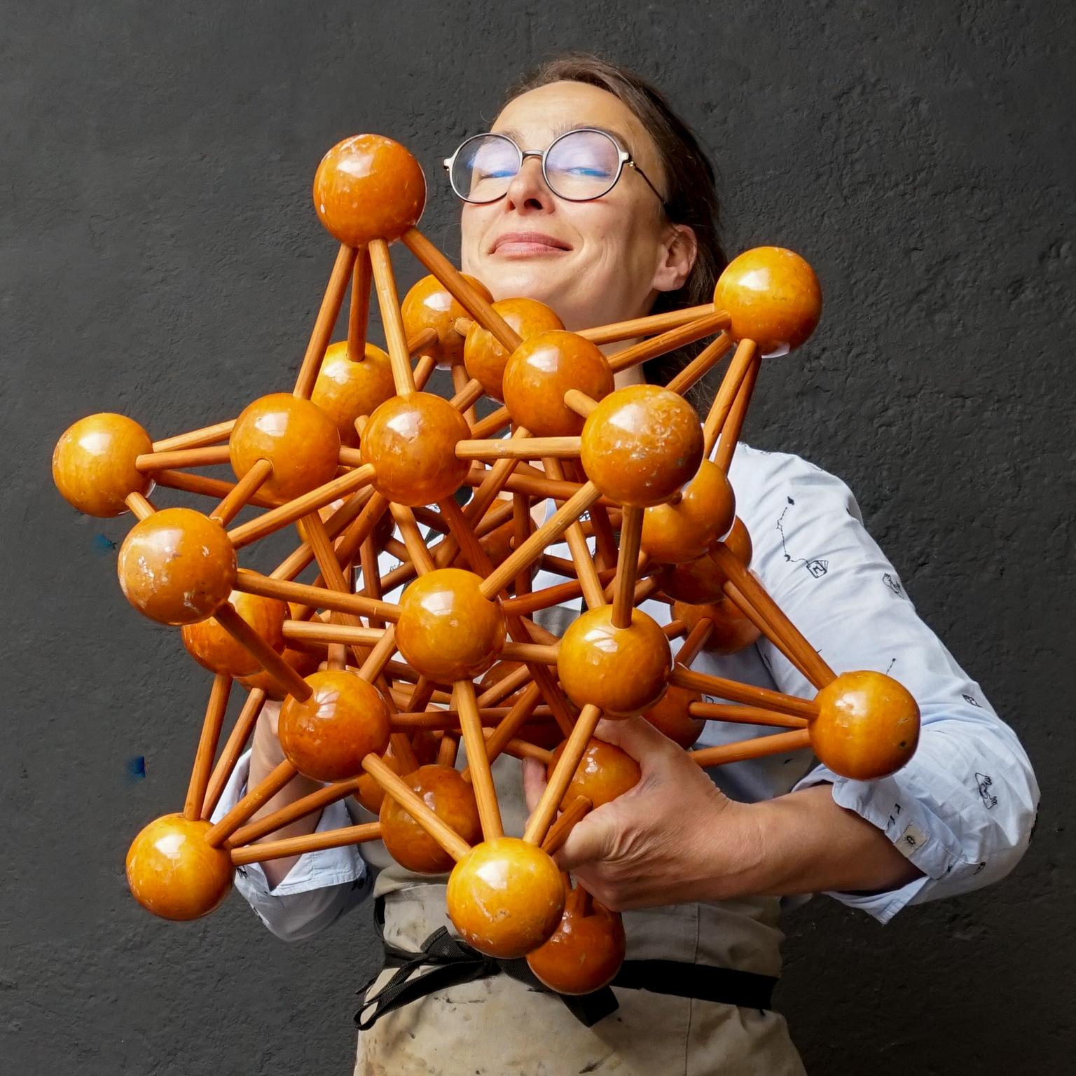 Very decorative large vintage 1950s lacquered wooden scale model of a molecule with atoms, probably once used in science class.
This large molecular model consists of 32 atoms (wooden lacquered balls) intertwined by wooden sticks (atomic bonds).