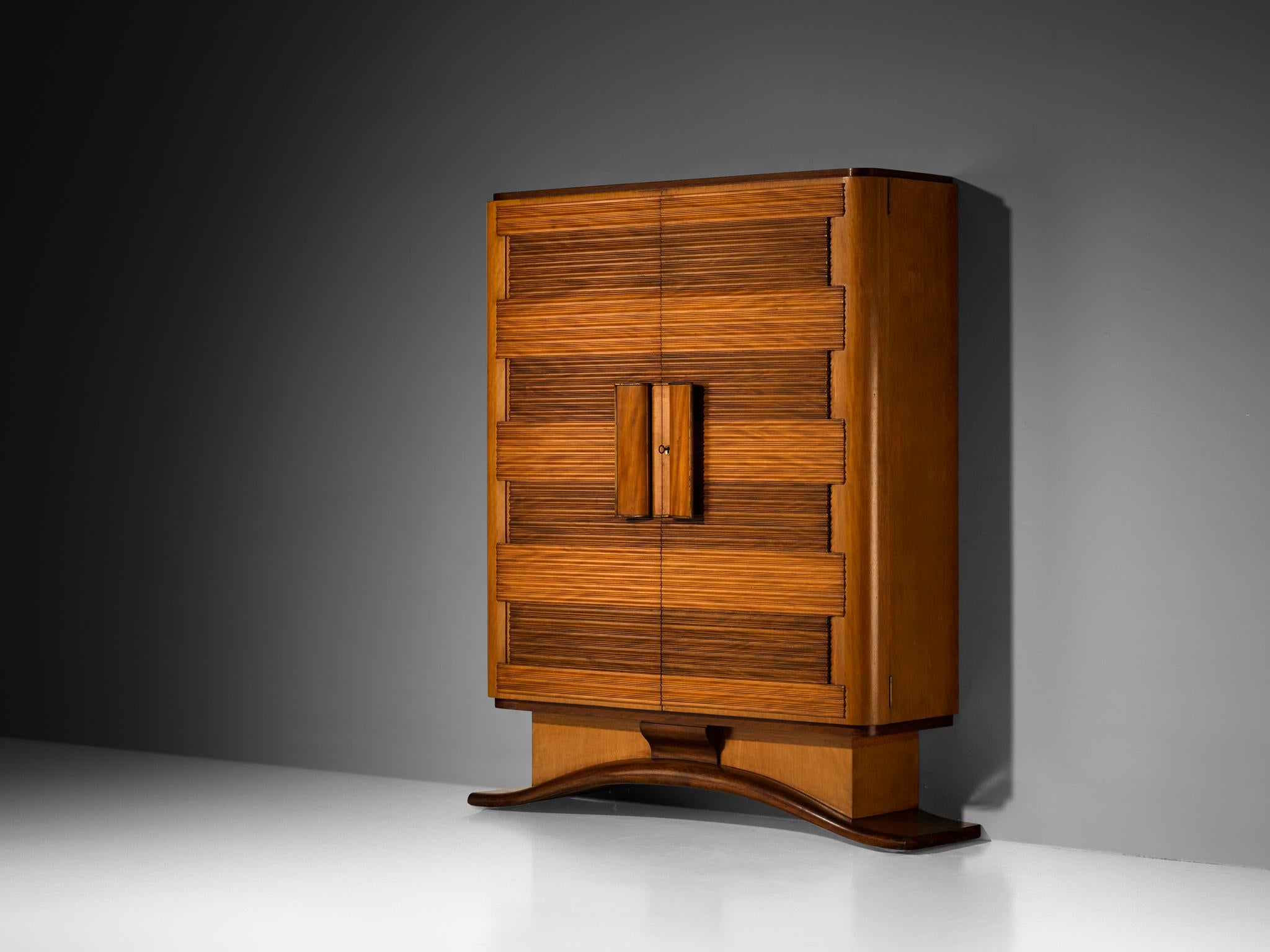 Armoire, acajou, verre miroir, verre, laiton, Italie, années 1950 

Cette charmante armoire se distingue par ses panneaux de porte graphiques, avec des lignes horizontales sculptées qui ajoutent du caractère et mettent en valeur le savoir-faire