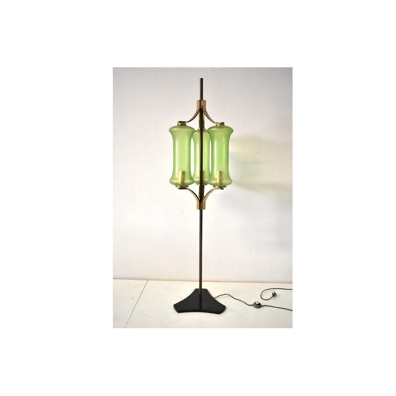 Mid-Century Modern, Floor lamp from the 1950s, Italian manufacture.
The lamp has a brass stem with a marble base.
The diffusers are made of green glass with brass elements above the diffusers that recall the stem.
It has a foot switch and an