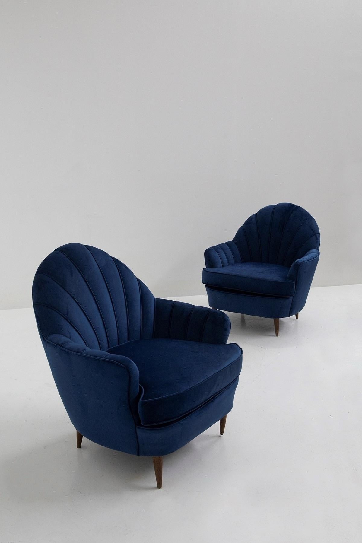 Mid-Century Modern 1950s Italian set of 2 Blue Shell Armchairs attributed to Guglielmo Ulrich. 
Shell-shaped in Blue velvet. with wooden feet.
These Armchairs showcase elegant form and rich details with the beautiful deep blue velvet. Although these