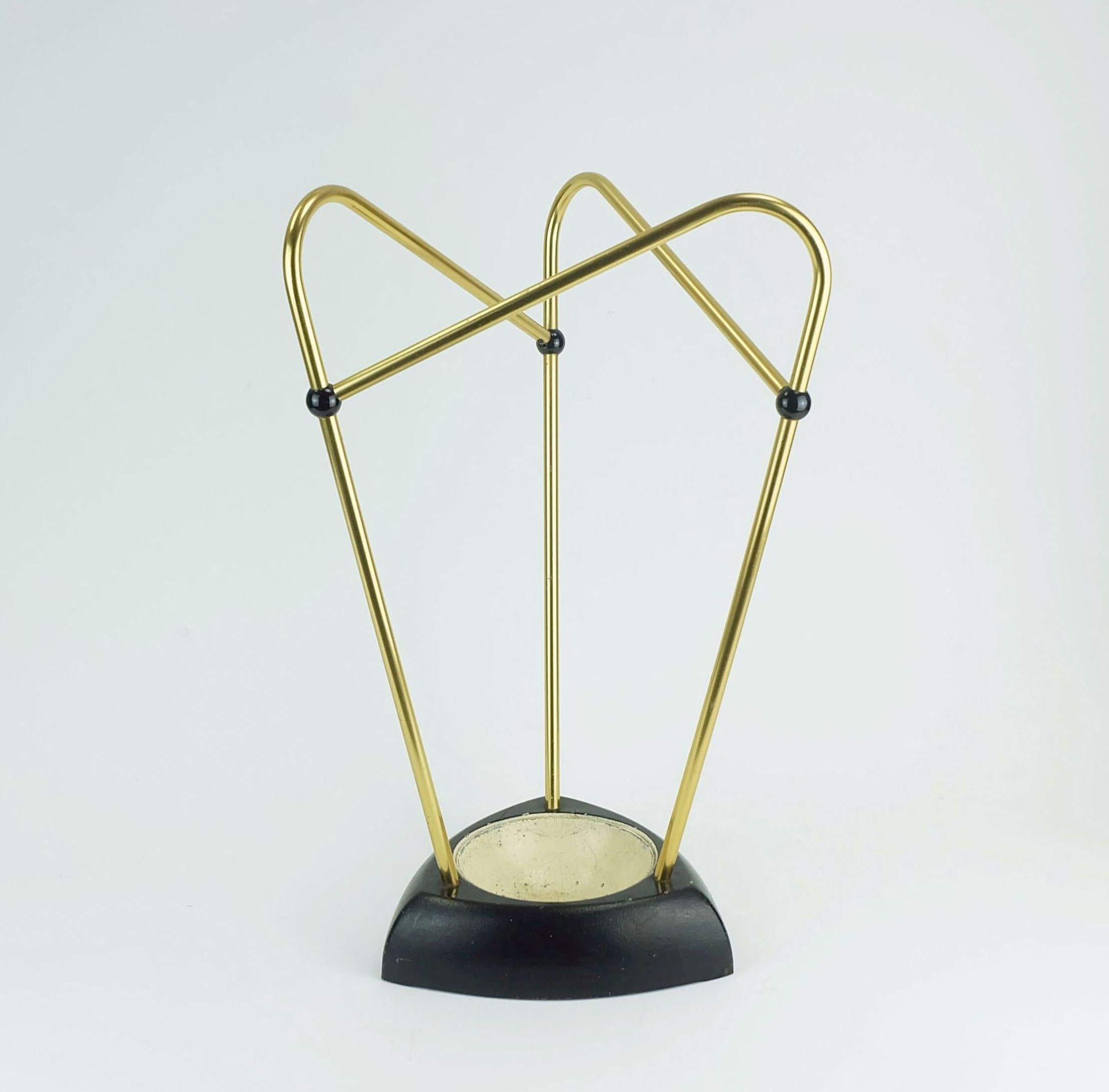 Portaombrelli della metà degli anni '50. Realizzato in ottone e ghisa verniciati in nero e beige chiaro. Elementi di collegamento in plastica nera. 

Dimensioni in cm:
Altezza 46 cm, larghezza 30 cm, profondità 30 cm.

Dimensioni in pollici:
Altezza