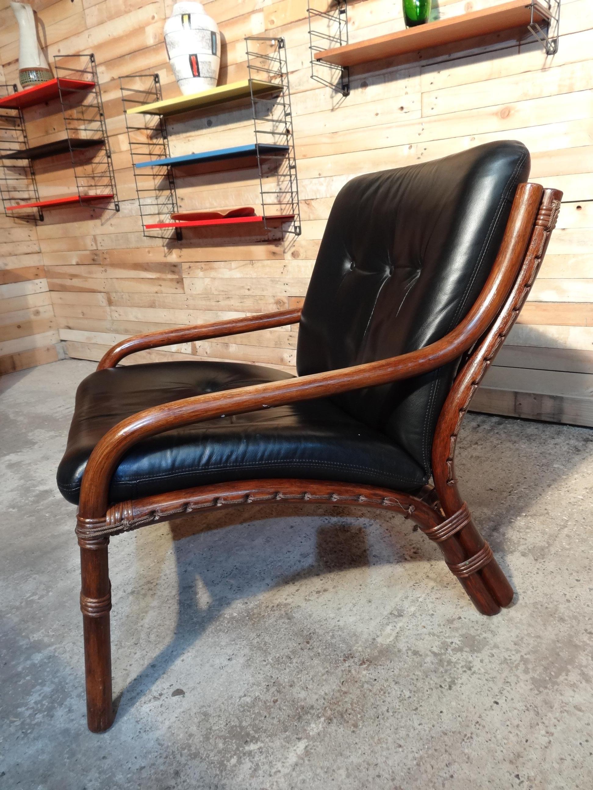 Mid-Century Modern 1960 colonial cane / bamboo designer sling-back black leather chair.

In very good vintage condition.

Measures: Seat height: 40cm, height: 80cm, depth: 75cm, width: 66cm.