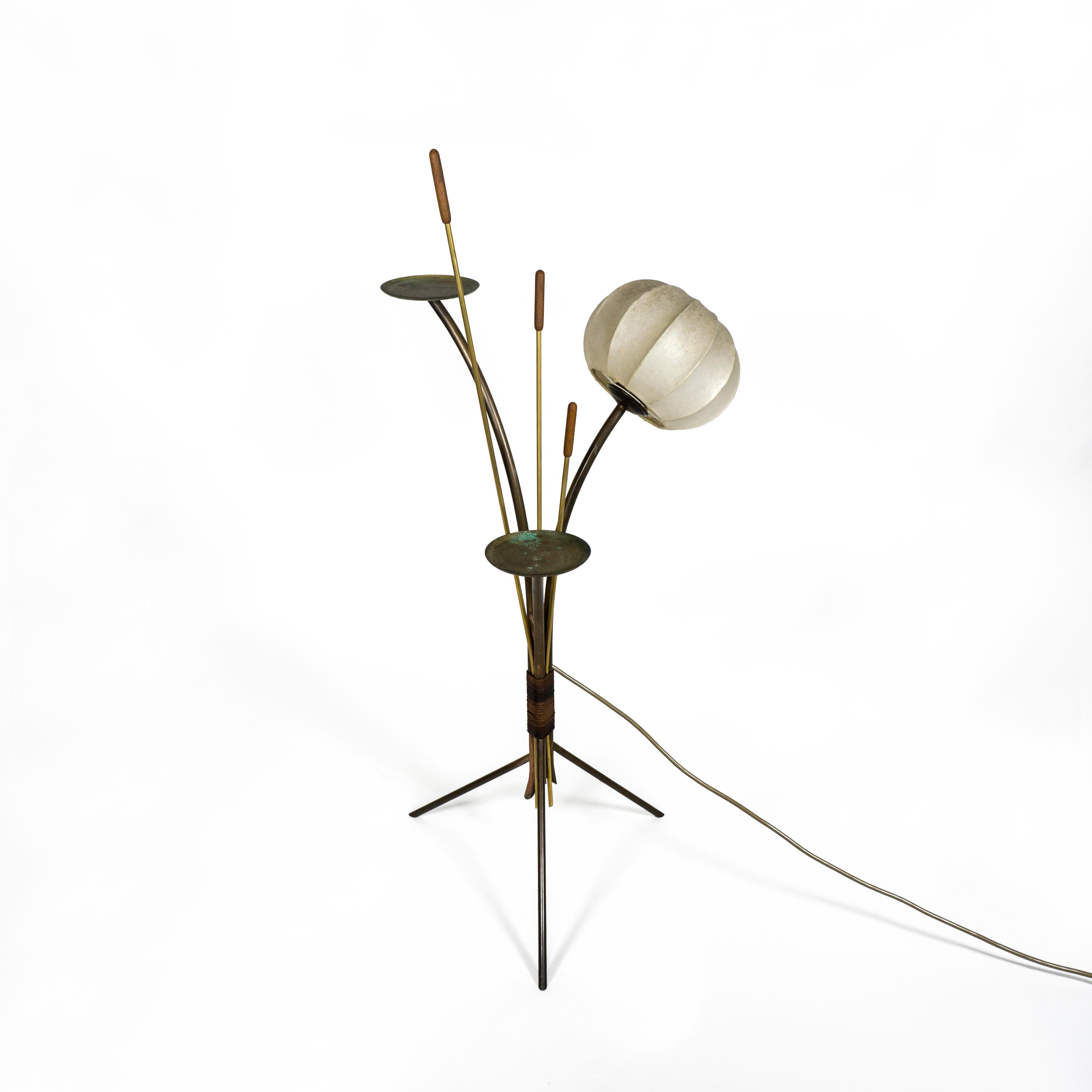 Exceptional and very stylish small brass floor lamp with two plates, three cattails and a cocoon lamp shade from the 1960s. 
The lamp consists of brass rods of different lengths, some bent and some straight.
This lamp is made for illumination but