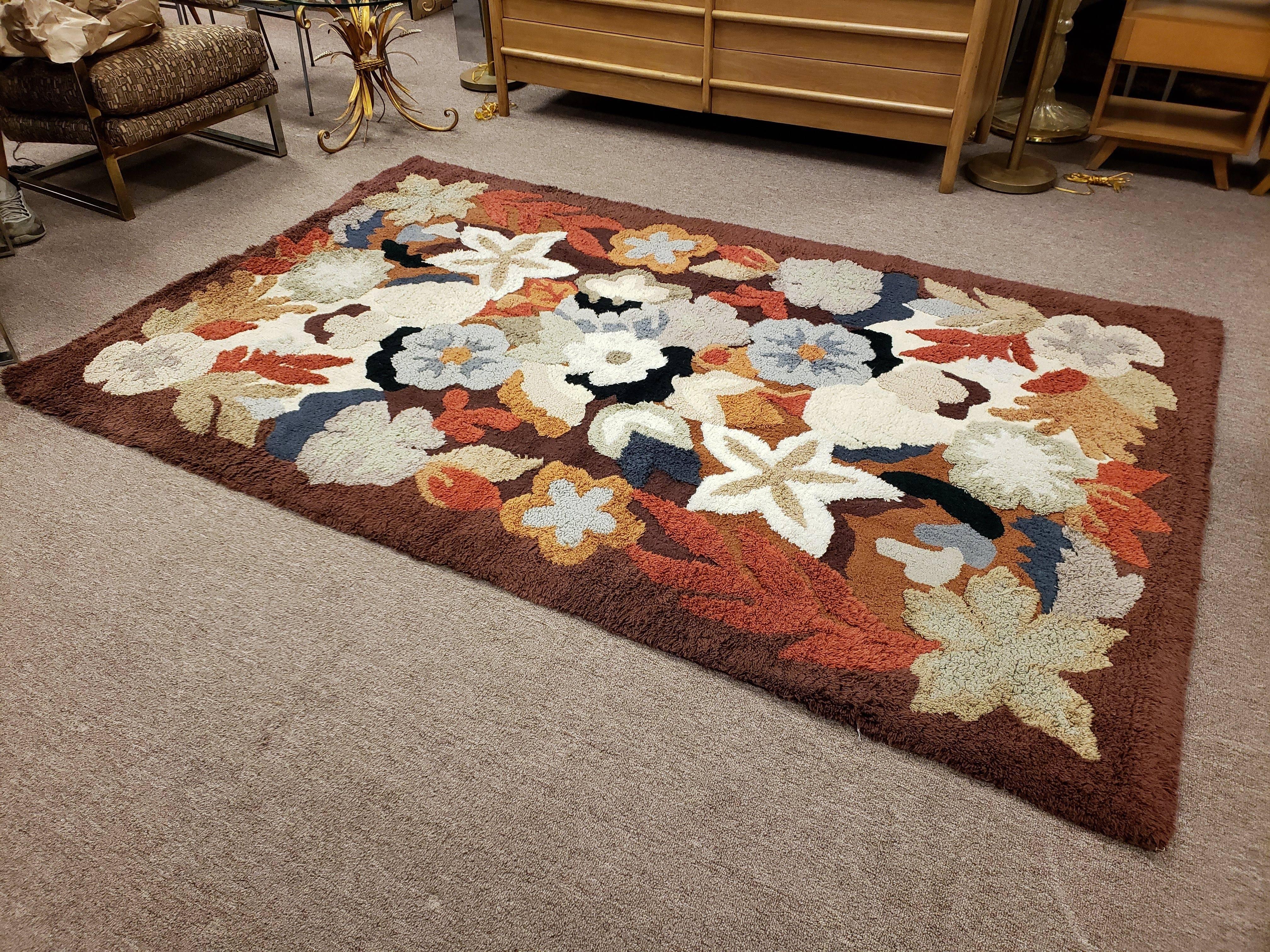 For your consideration is a Mid-Century Modern floral motif hand-knotted wool rug from the 1960s. Just back from being professionally cleaned and ready for your space. It's multi colors consist of burnt orange, blue's and gray's with touches of
