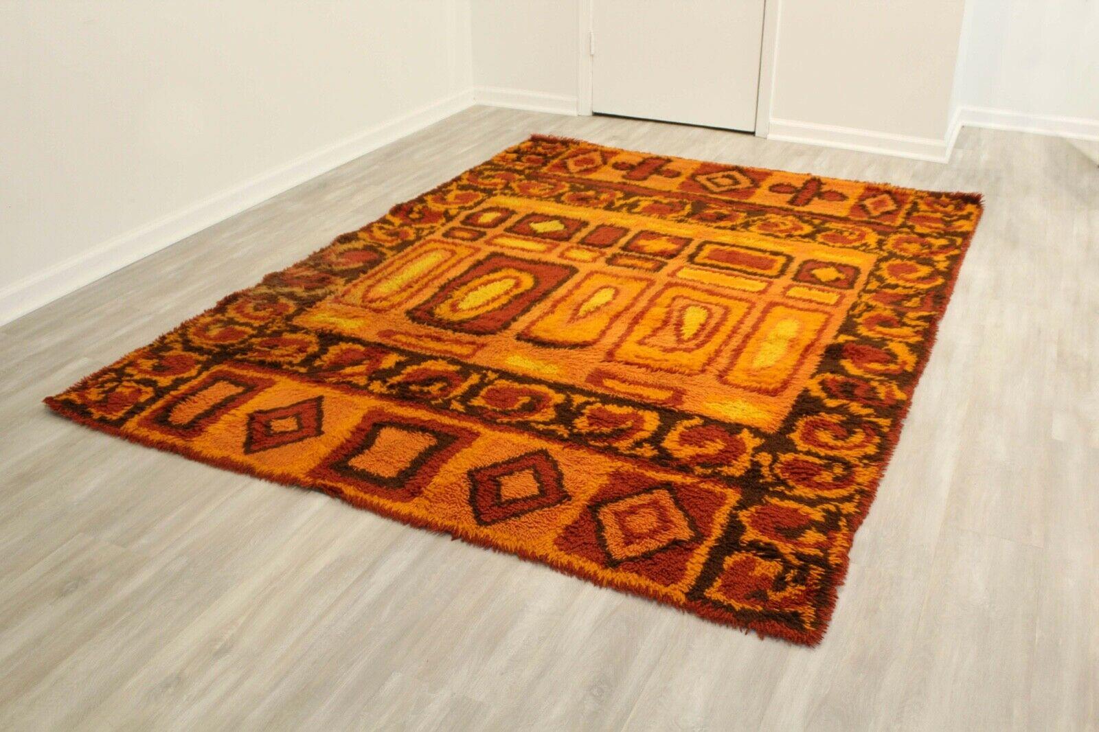Twisted yarns in warm tones of red, orange and yellow detail this mid century modern area Rya rug, made in Finland. The abstract pattern and colors offers a focal point for any Mid Century Modern or modern home. In good vintage