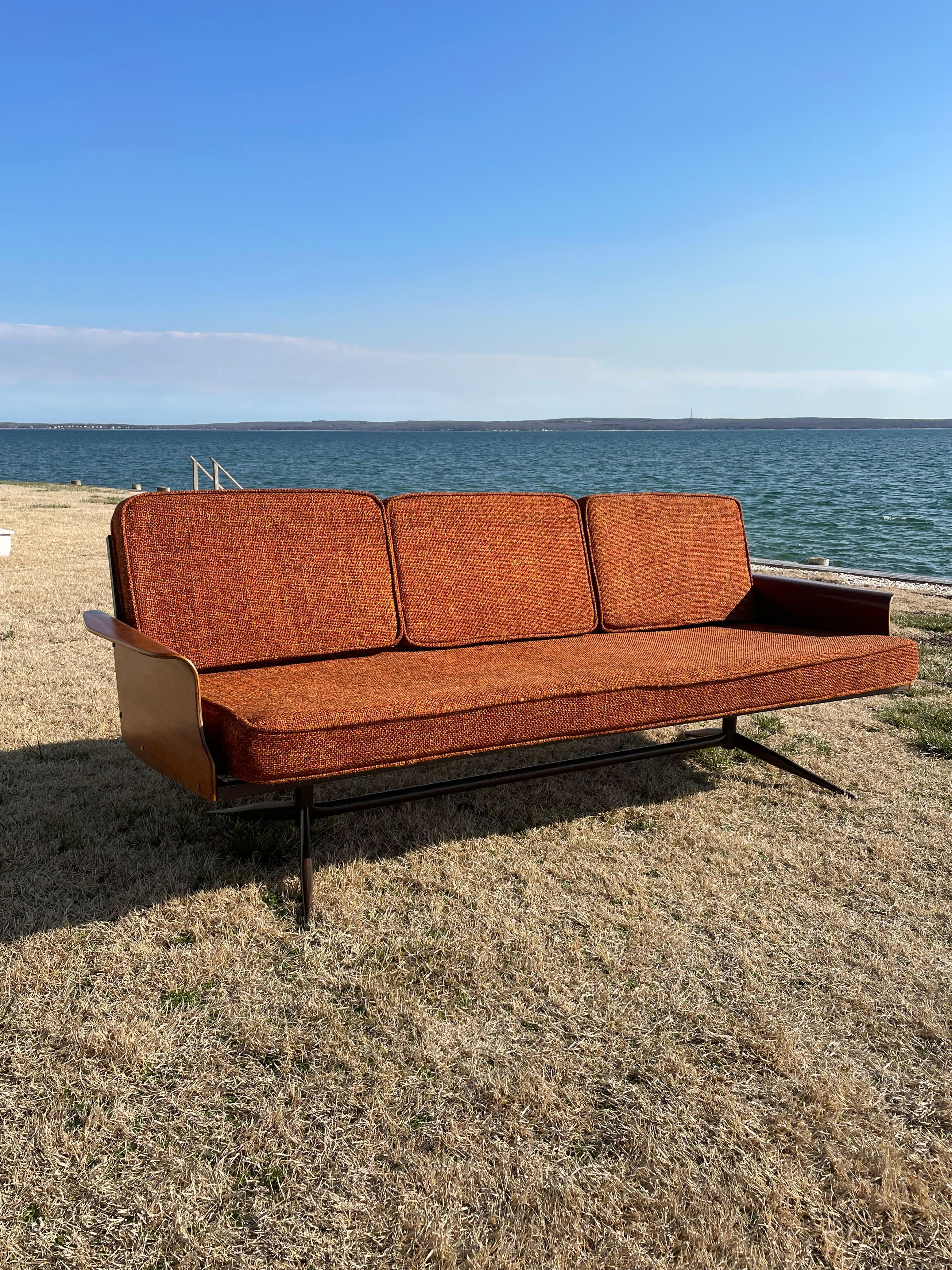 Este sofá flotante de los años 60 fue fabricado por Viko Baumritter , una empresa de muebles estadounidense que más tarde se convirtió en Ethan Allen. El sofá tiene estructura metálica y patas de metal con imitación de madera veteada. Los brazos son