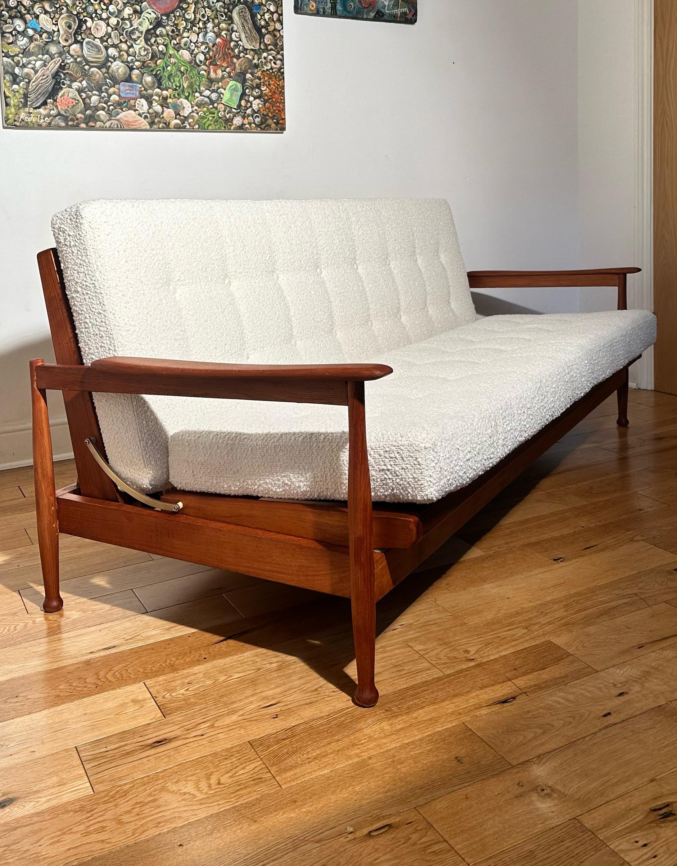 Stunning mid-century Guy Rogers ‘Manhattan’ sofa bed manufactured in the 1960s 
Beautifully made from top quality solid teak with beautifully crafted edged armrests.
It has been fully restored and reupholstered at great cost with quality