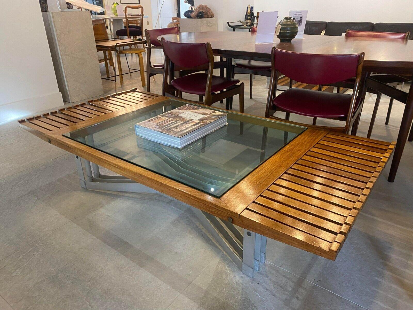 A rare Modernist coffee table of Danish design, circa 1970, the surface constructed of mahogany strips / beams inset with a glass centre, on an aluminium base. 

Dimensions:
height: 39.2 cm.
width: 180.5 cm.
depth: 88.7 cm.