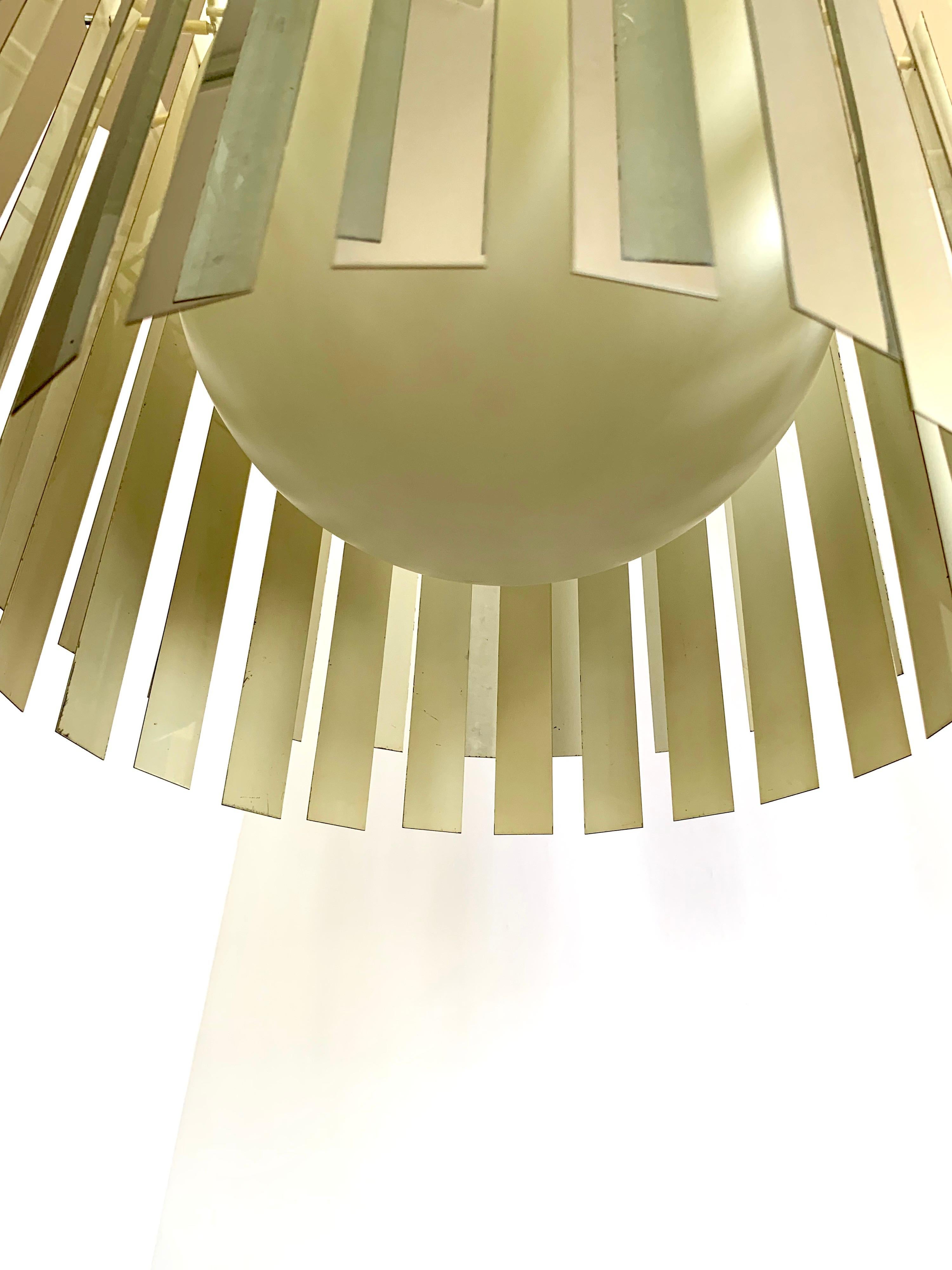 Unusual in every way, with its mirrored metallic prisms hanging to form a mirror ball effect, this true period midcentury chandelier is guaranteed to set your home apart from your friends and neighbors. Wired in the USA and in perfect work order,