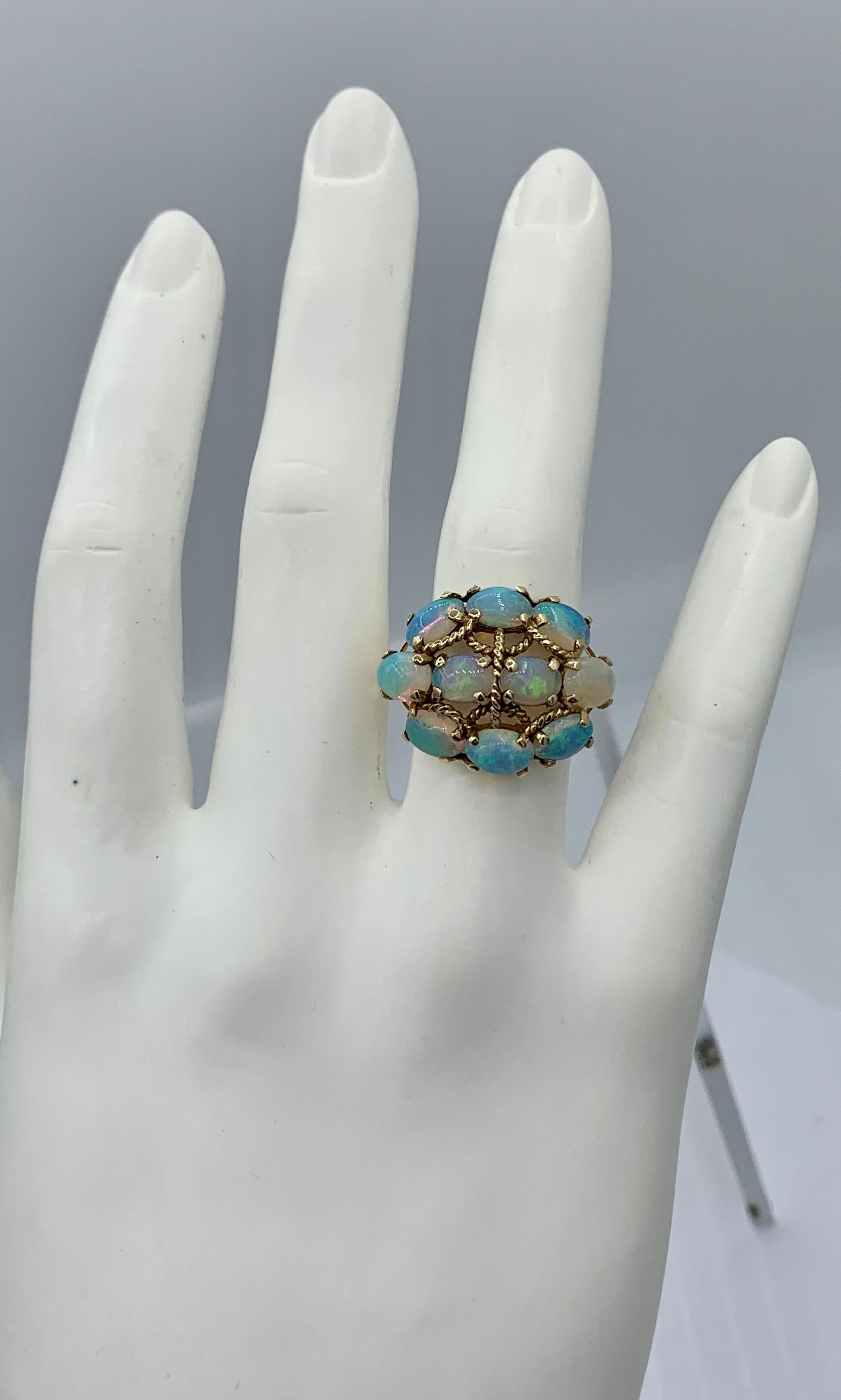 THIS IS A WONDERFUL MID-CENTURY MODERNIST EAMES ERA 2 CARAT OPAL RING IN 14K YELLOW GOLD WITH A STUNNING OVAL OPAL CABOCHON GEM.
The effect of the gorgeous natural opal in the wondrous mid-century geometric design in 14K yellow gold create a magical