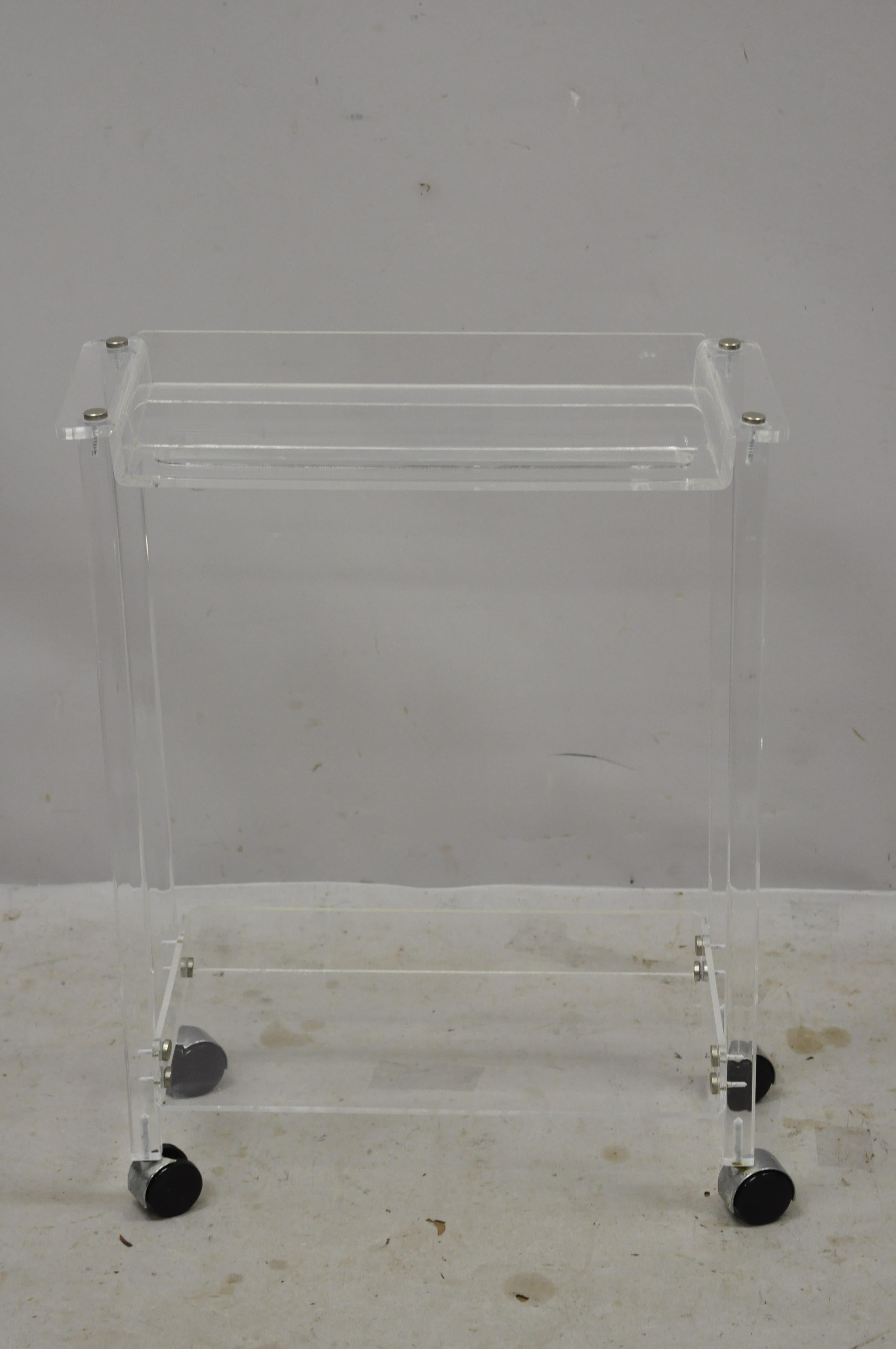 Mid-Century Modern 2 tier Lucite small rolling bar cart serving towel rack stand. Item features 2 tiers, rolling casters, clean modernist lines, great style and form. Great for use as a bathroom or kitchen towel rack or small bar cart. circa mid to